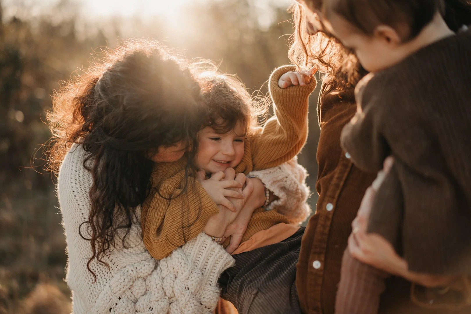 Mama umarmt ihr Kind auf der Wiese.“