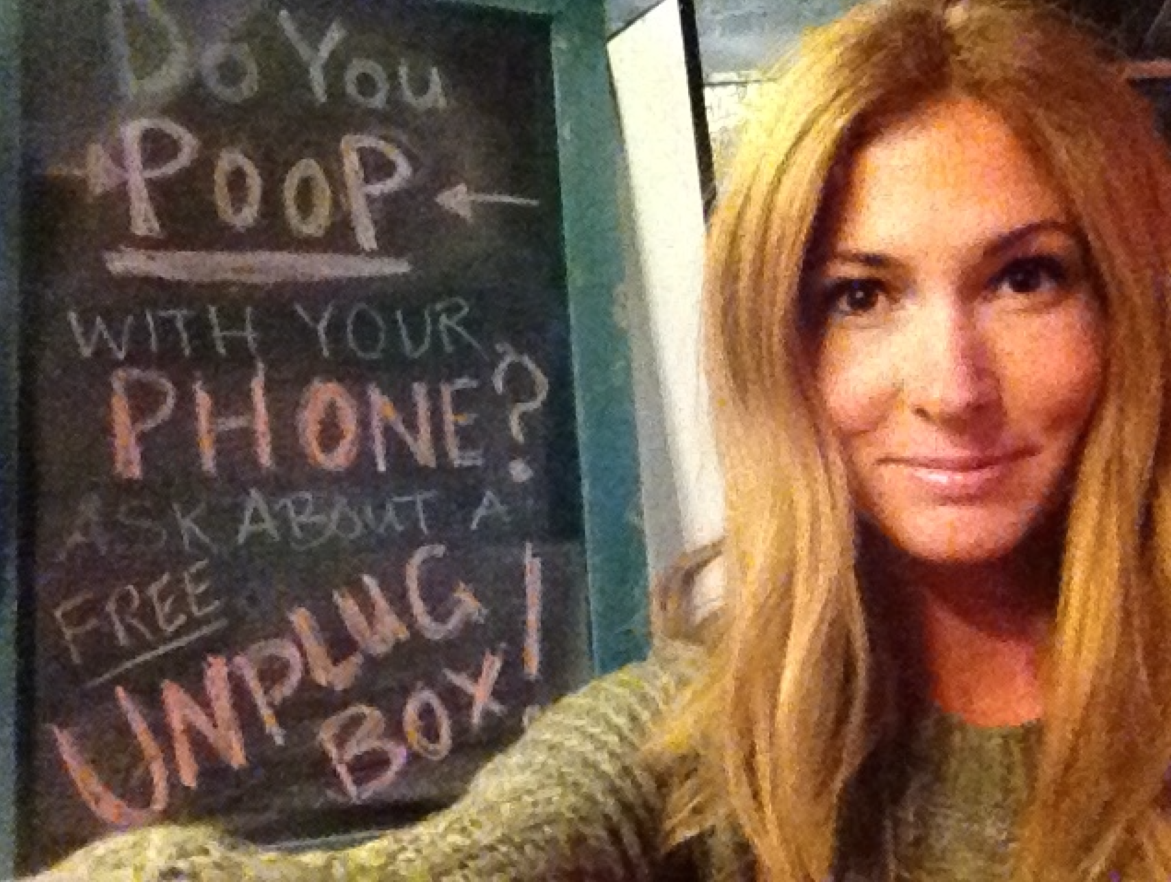 Jessica Elefante at a 2014 Folk Rebellion pop-up at Brooklyn Night Bazaar beside a “Do You Poop With Your Phone?” sign promoting the Unplug Box.