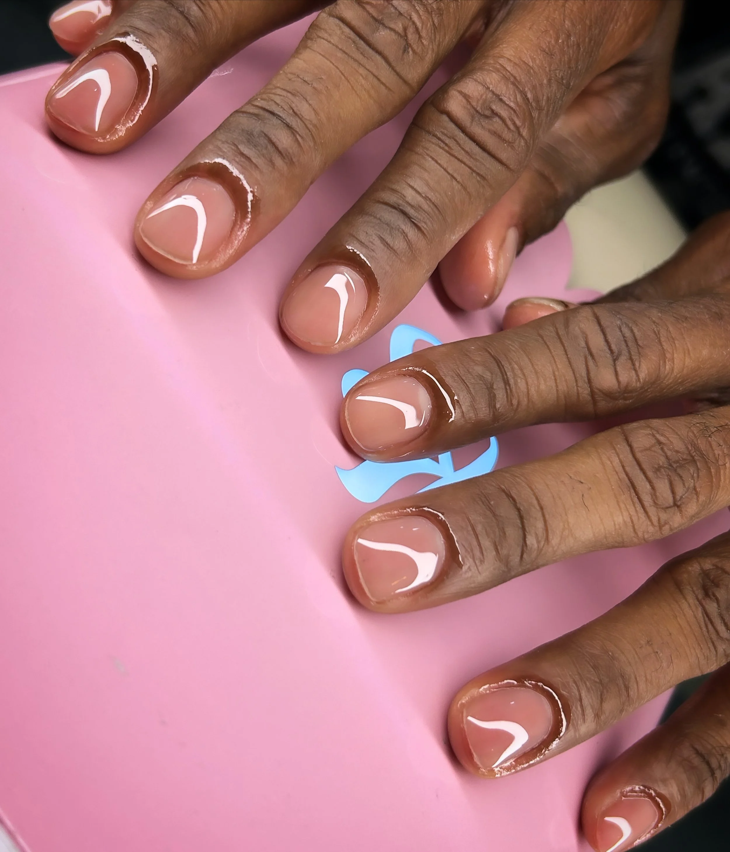 neatly manicured nails, showing shiny, clear finish.