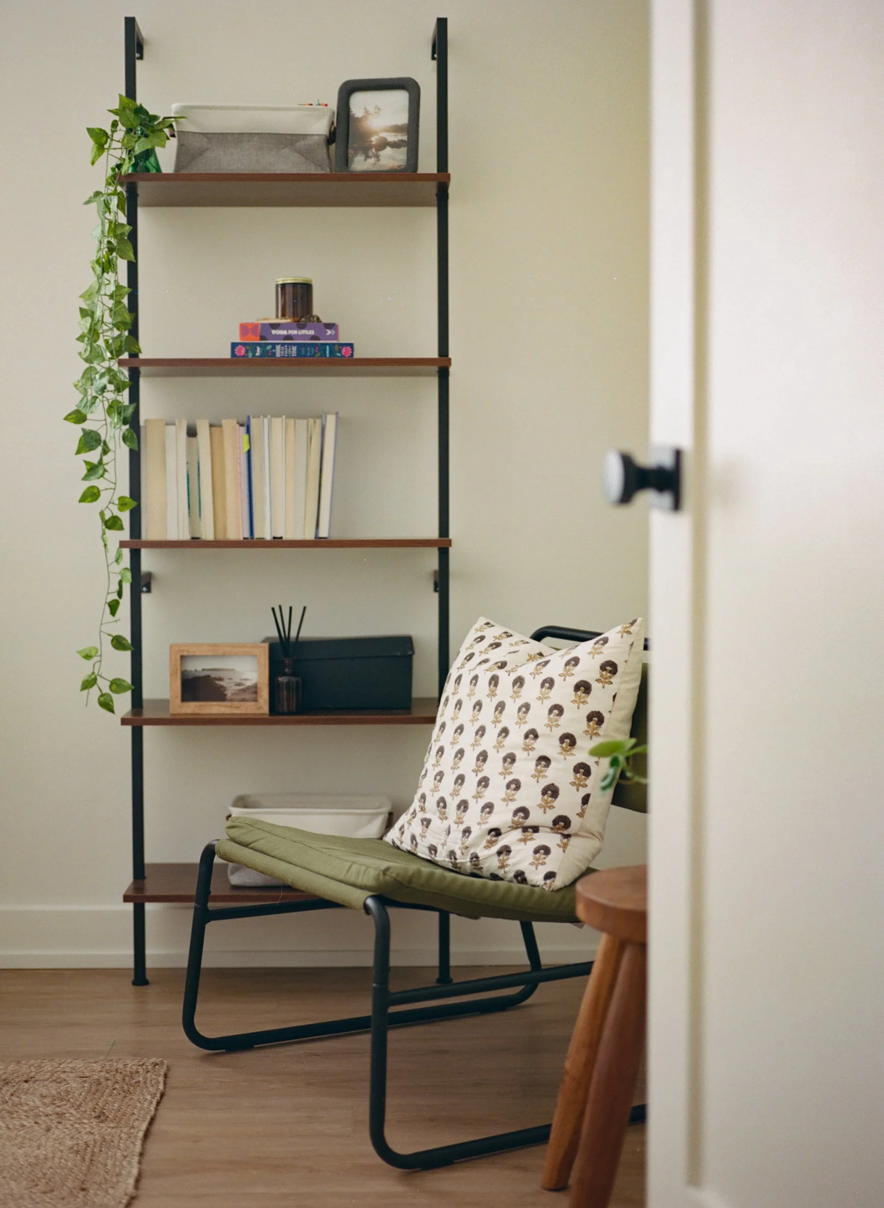A bookshelf and green chair in the office of a female Asian therapist in downtown Guelph offering therapy for burnout in Ontario