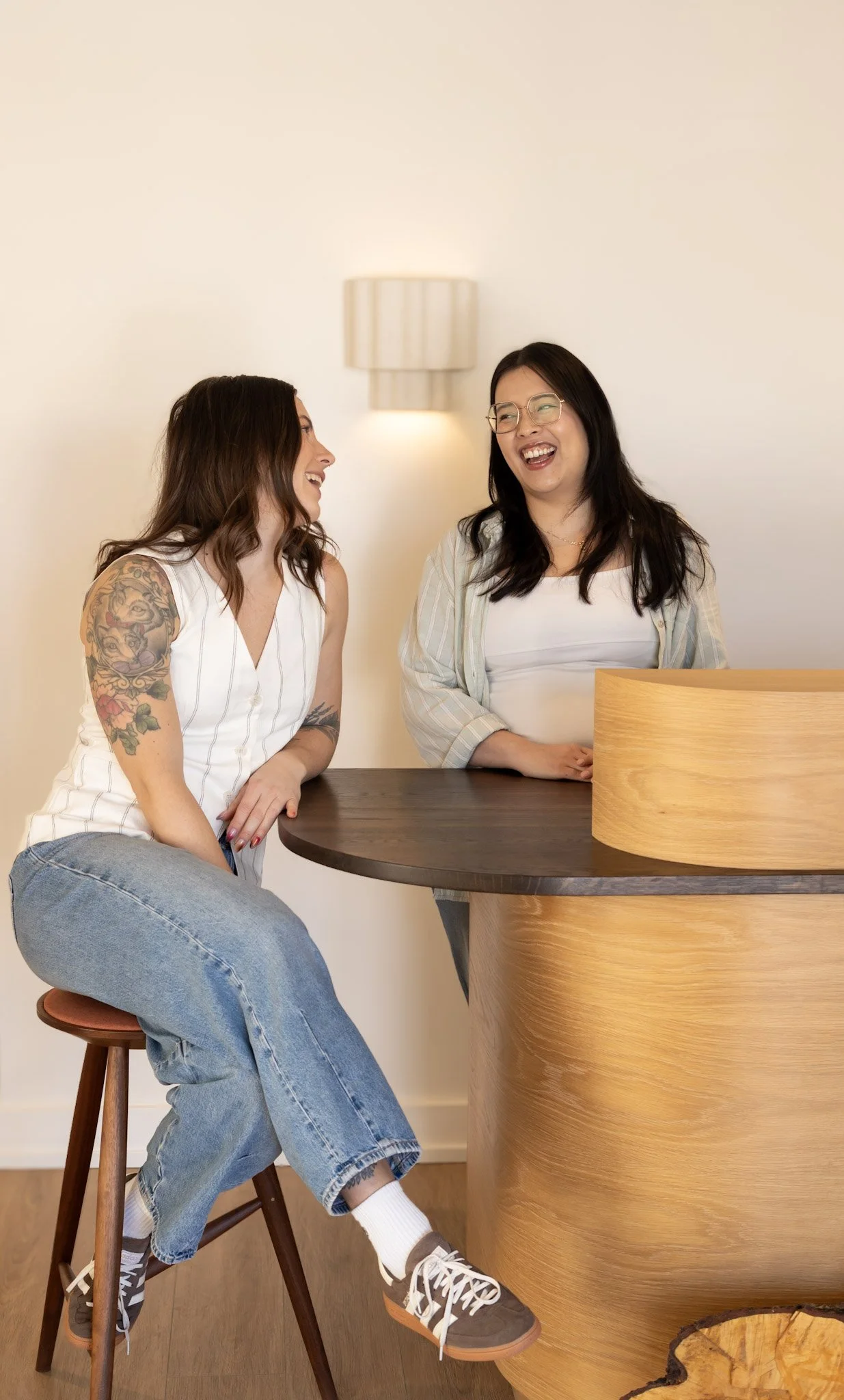 2 female therapists sitting in their Guelph counselling office laughing.