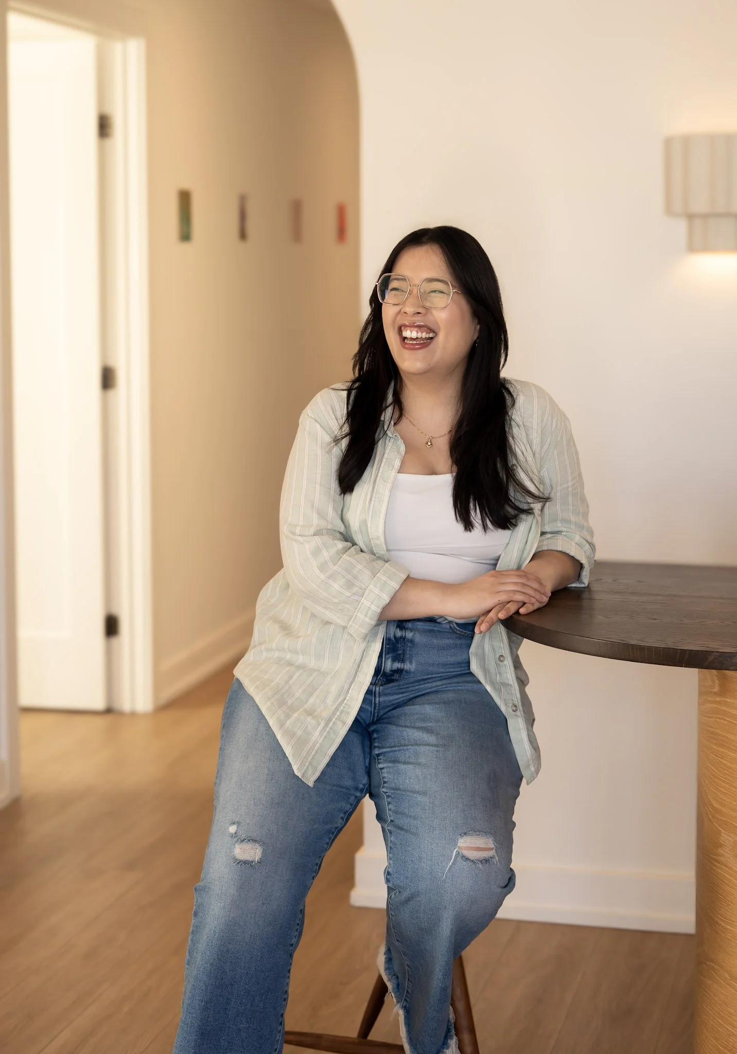 An Asian female therapist in Ontario laughing about therapy for kids in Guelph