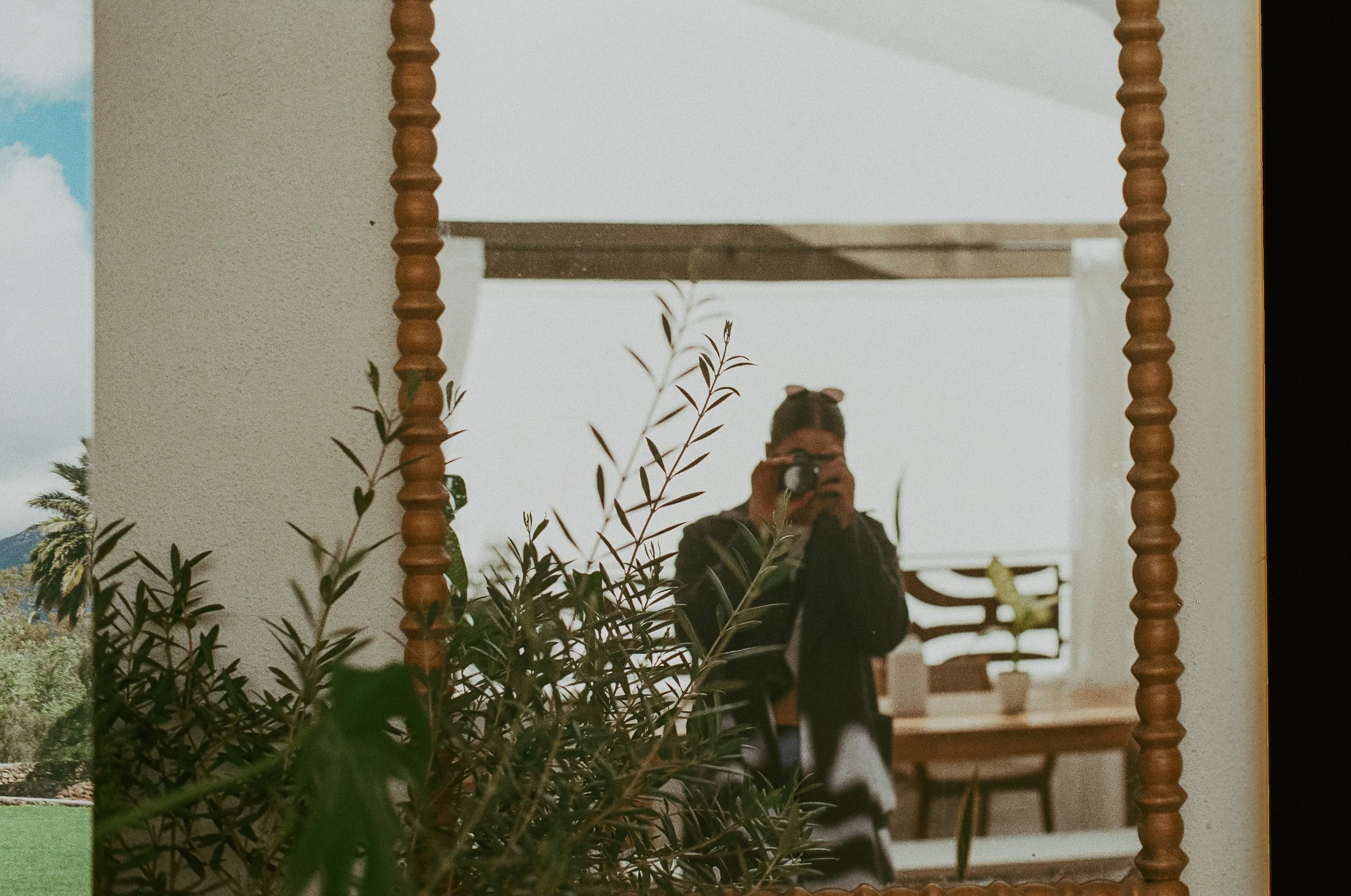 A female therapist in downtown Guelph in a therapy office in Ontario taking a film photo in a mirror