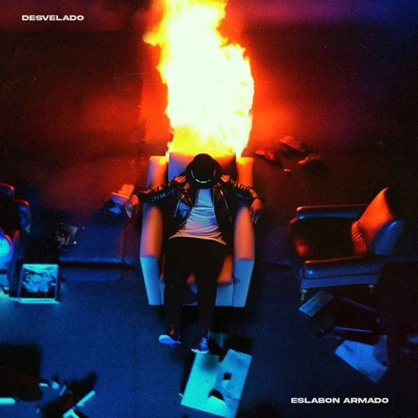 Person sitting in a leather chair with a fire erupting from behind, surrounded by other chairs in a dark room.