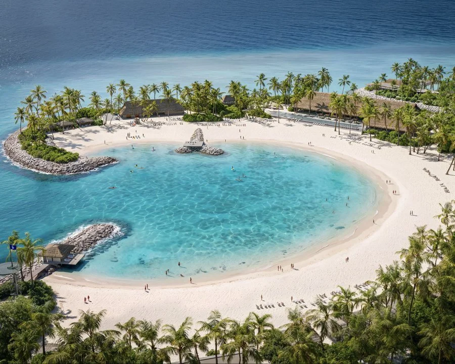 Rendering of a sheltered lagoon cove at MSC Sandy Cay with white aragonite sand, thatched pavilions and palm trees