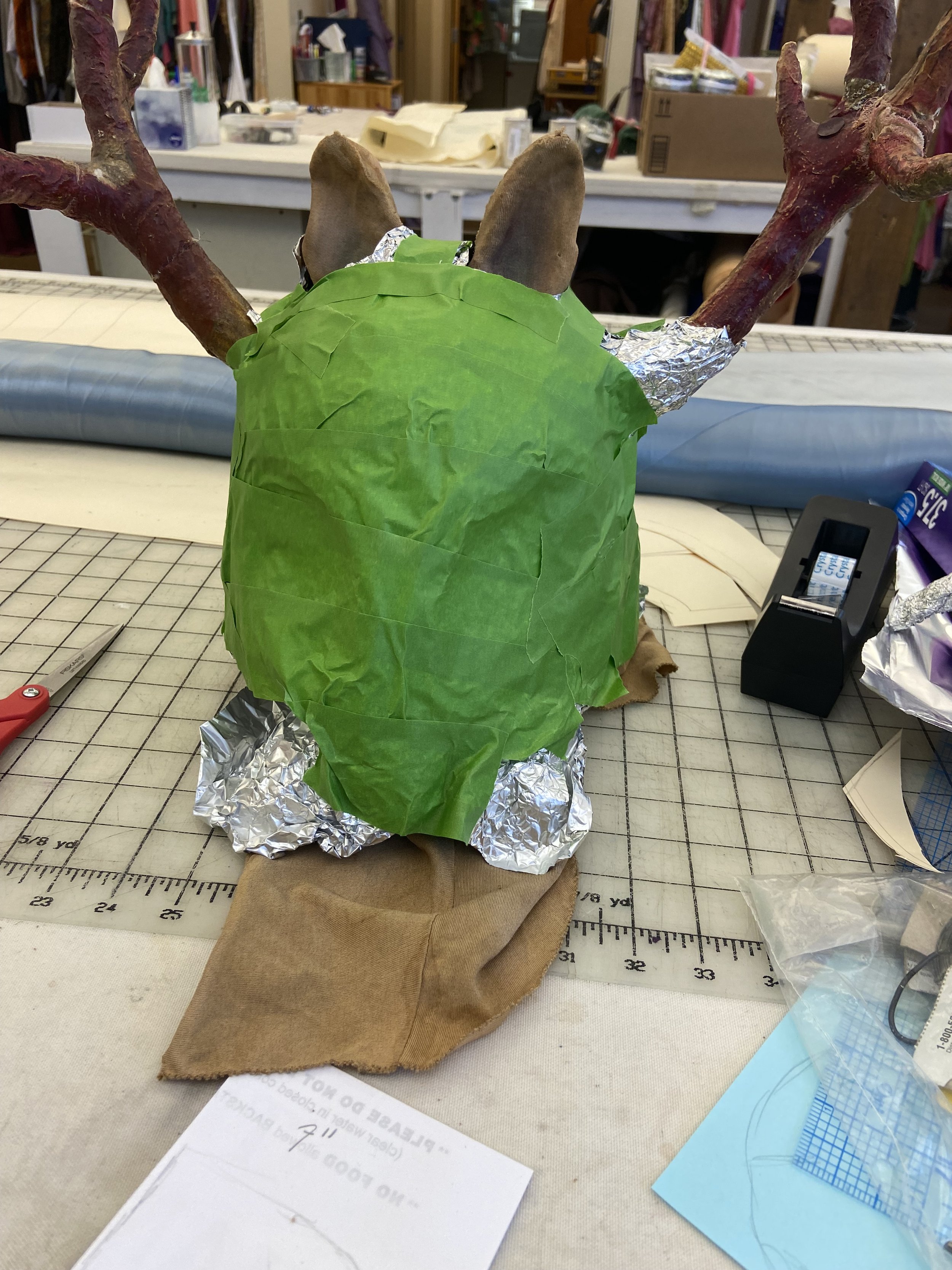 Deer mask covered in foil and tape to make a pattern