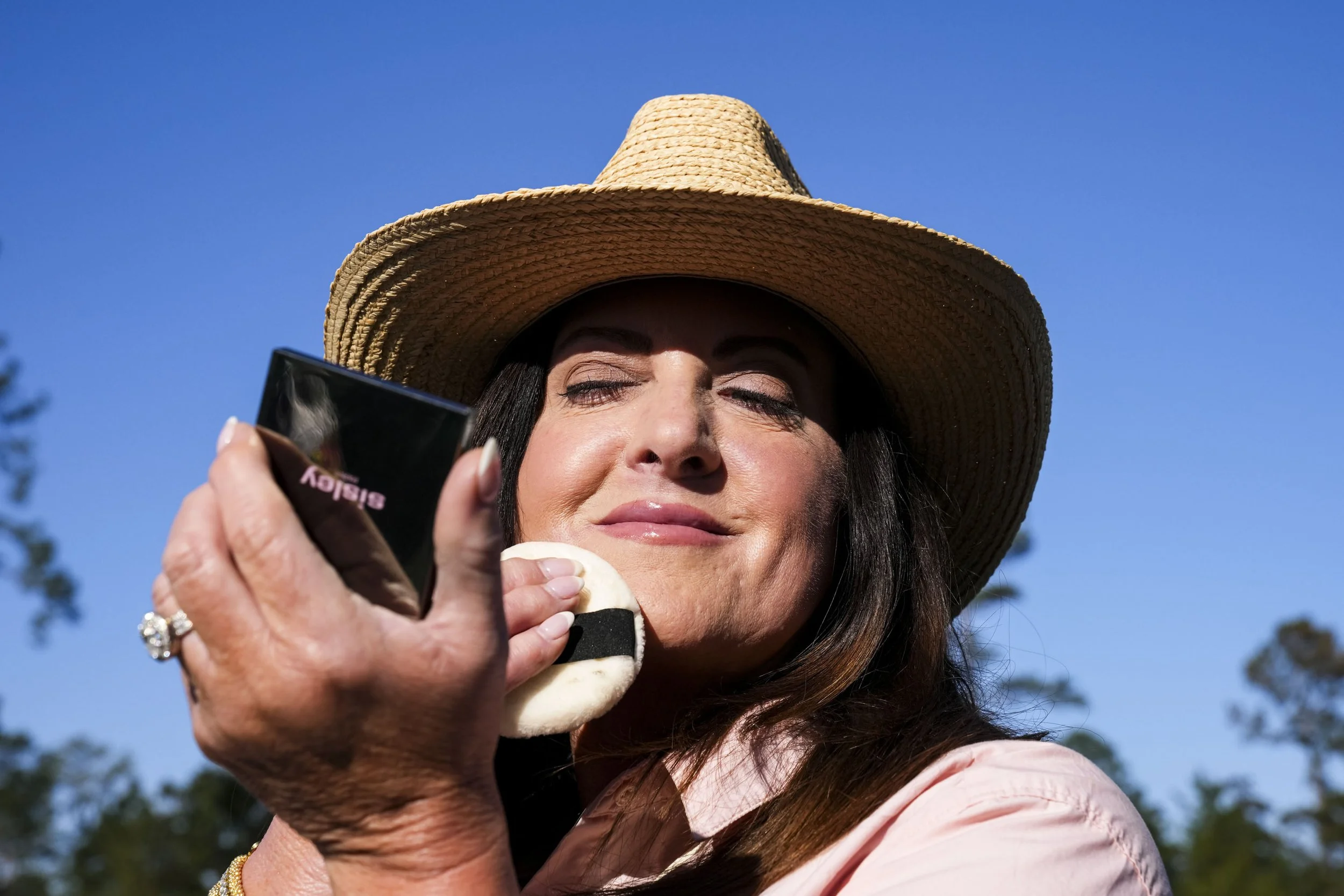 Michelle Satcher of Edgefield, S.C., applies makeup while out on the course during a practice round for the Masters Tournament at Augusta National Golf Club in Augusta, Ga., on Tuesday, April 8, 2025. Mandatory Credit: Grace Smith-Imagn Images