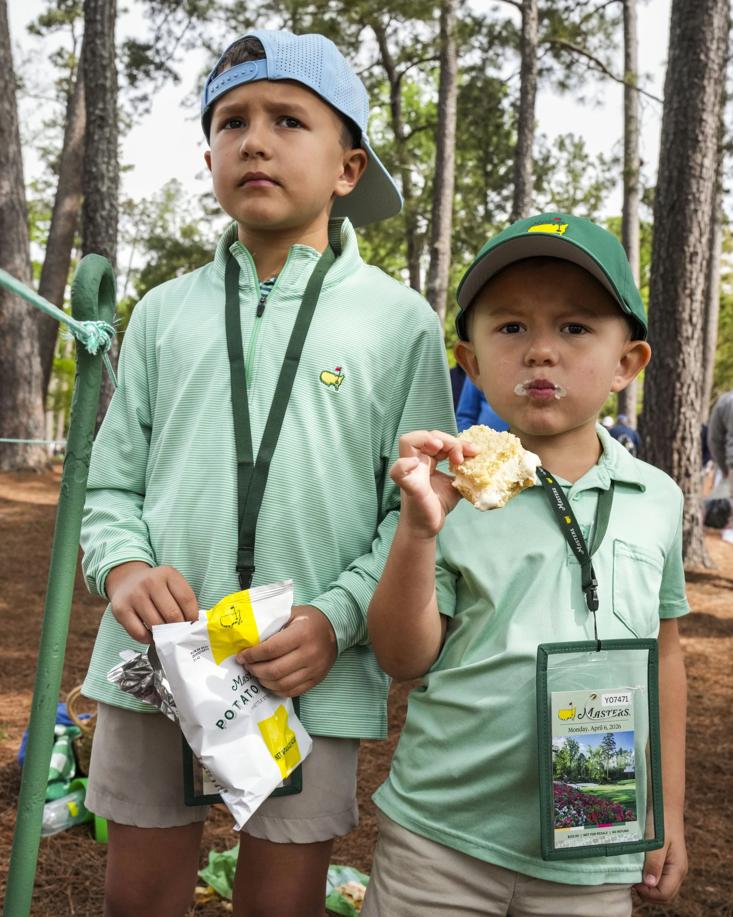 William (left), 8, and Charles Hatsfelt, 4, of Baton Rouge, La., eat a snack while watching the action on Amen Corner on Monday, April 6, 2026, during a practice round for the Masters Tournament at Augusta National Golf Club. Mandatory Credit: Grace 