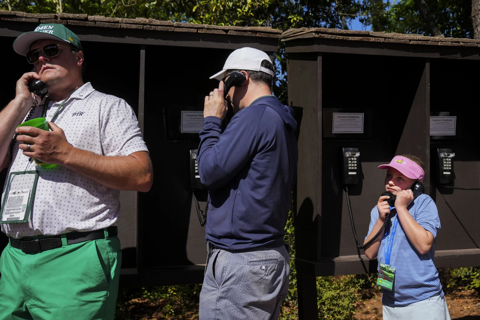 Ophelia Martin (right), 9, of Athens, Ga., talks with her brother and sister from a courtesy phone near the fourth hole Friday, April 10, 2026, during the second round of the Masters Tournament at Augusta National Golf Club. Mandatory Credit: Grace S