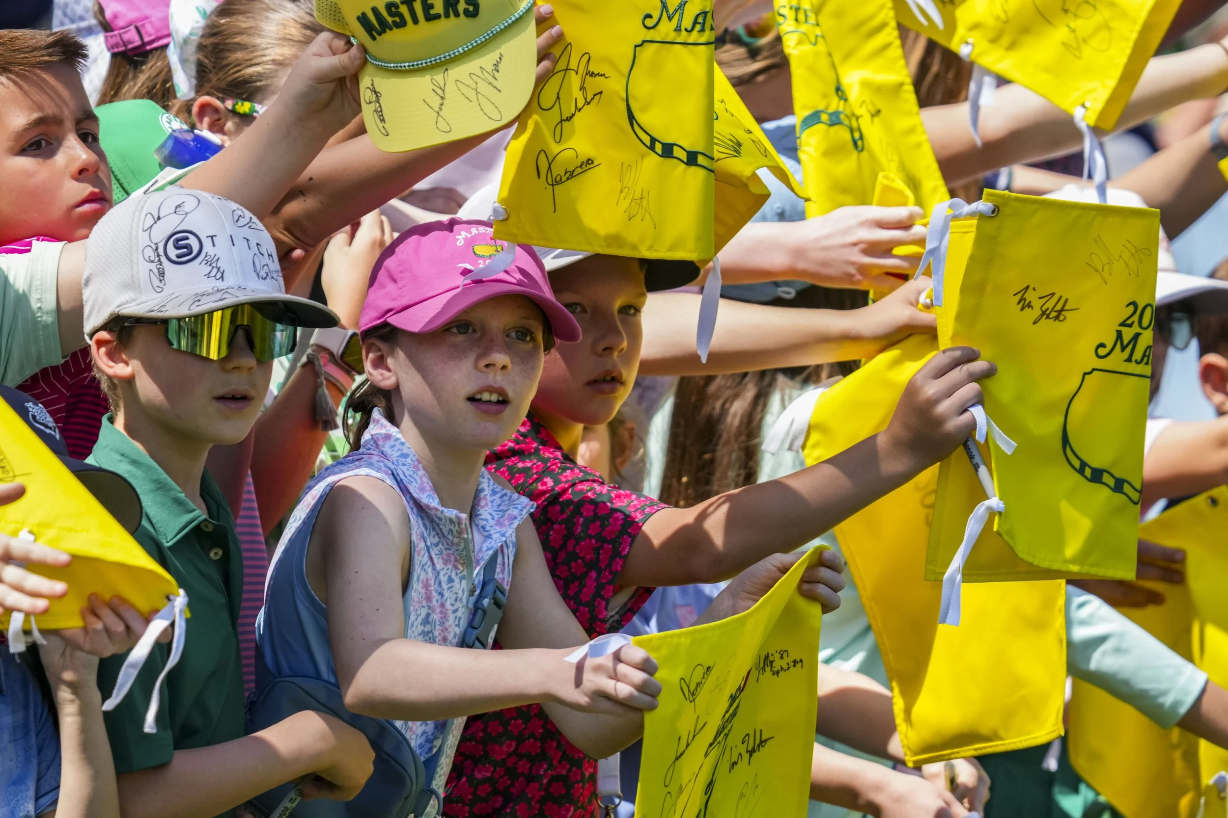 Young fans line the rope with merchandise as golfers walk by during the Par 3 Contest at Augusta National Golf Club in Augusta, Ga., on Wednesday, April 9, 2025. Mandatory Credit: Grace Smith-Imagn Images