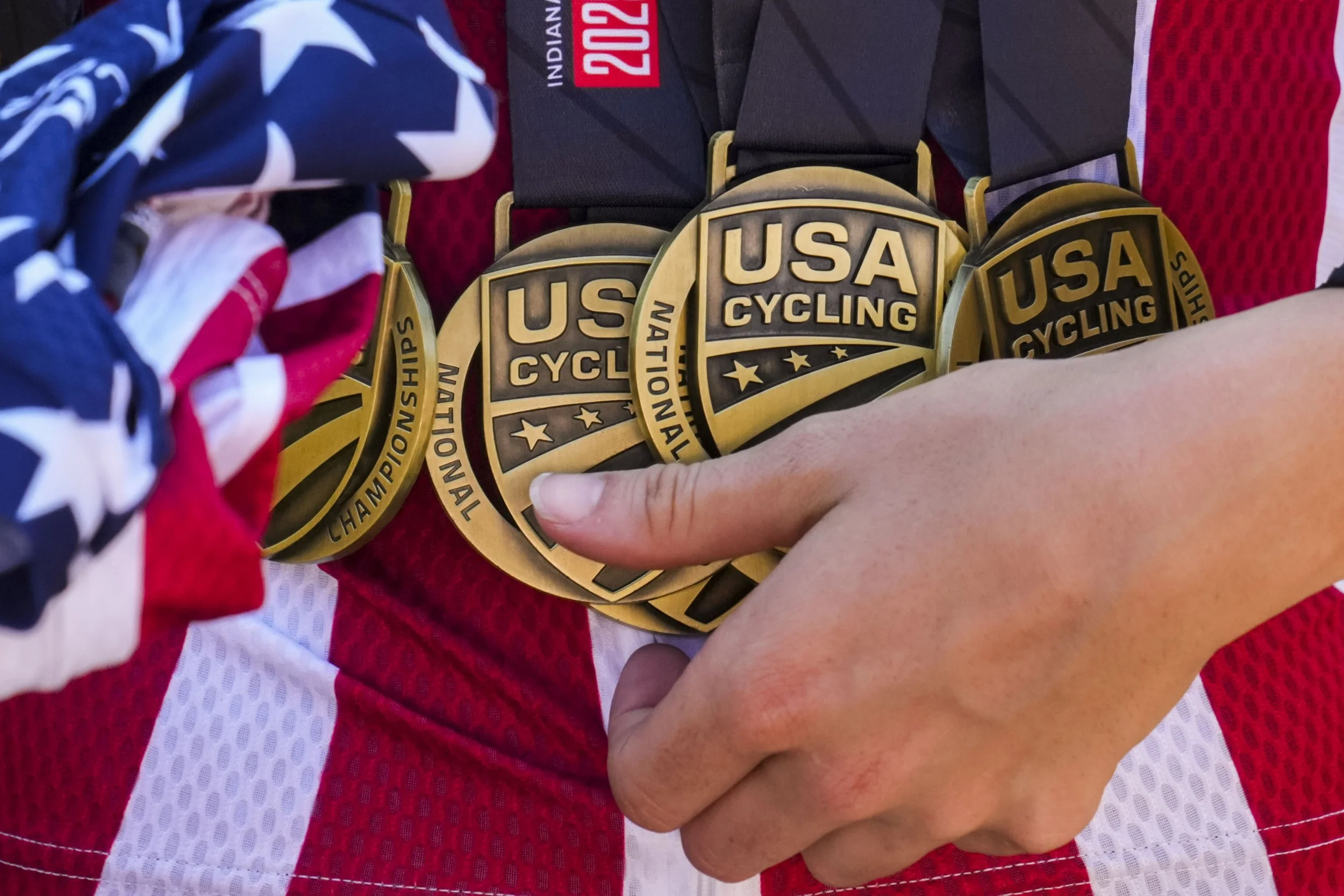 Stephanie Lawrence adjusts her gold medals after the final day of the 2025 Collegiate Track National Championships at Major Taylor Velodrome in Indianapolis, Ind., on Sunday, Sept. 14, 2025. Over the past four years of college, Lawrence has pushed he