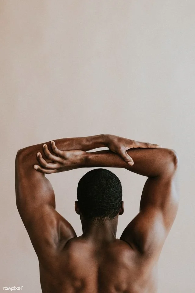 Back view of a shirtless man with muscular arms stretching his arms and locking his hands behind his head