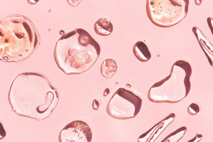 Close-up of water droplets on a pink surface.