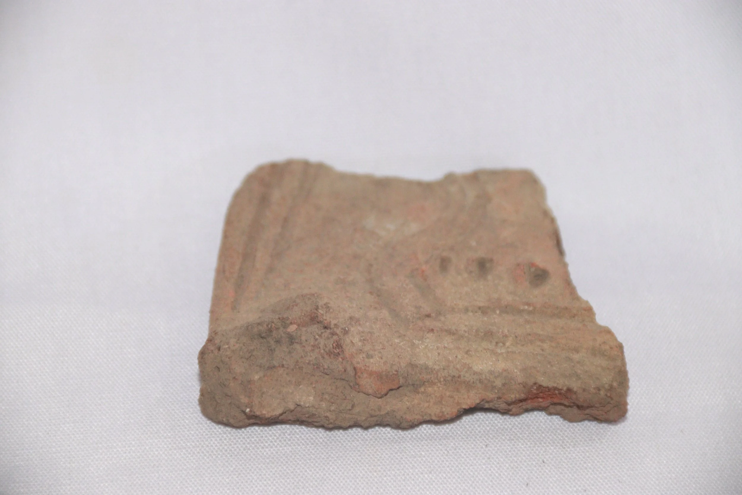 archive number: r-1-022d
object reference: 
Pottery fragments
origin: Banda
date: -
notes: Many of these pottery pieces are shaped like bird heads and ears, usually used as handles on clay vessels. On the pottery fragments we can see decorative patte