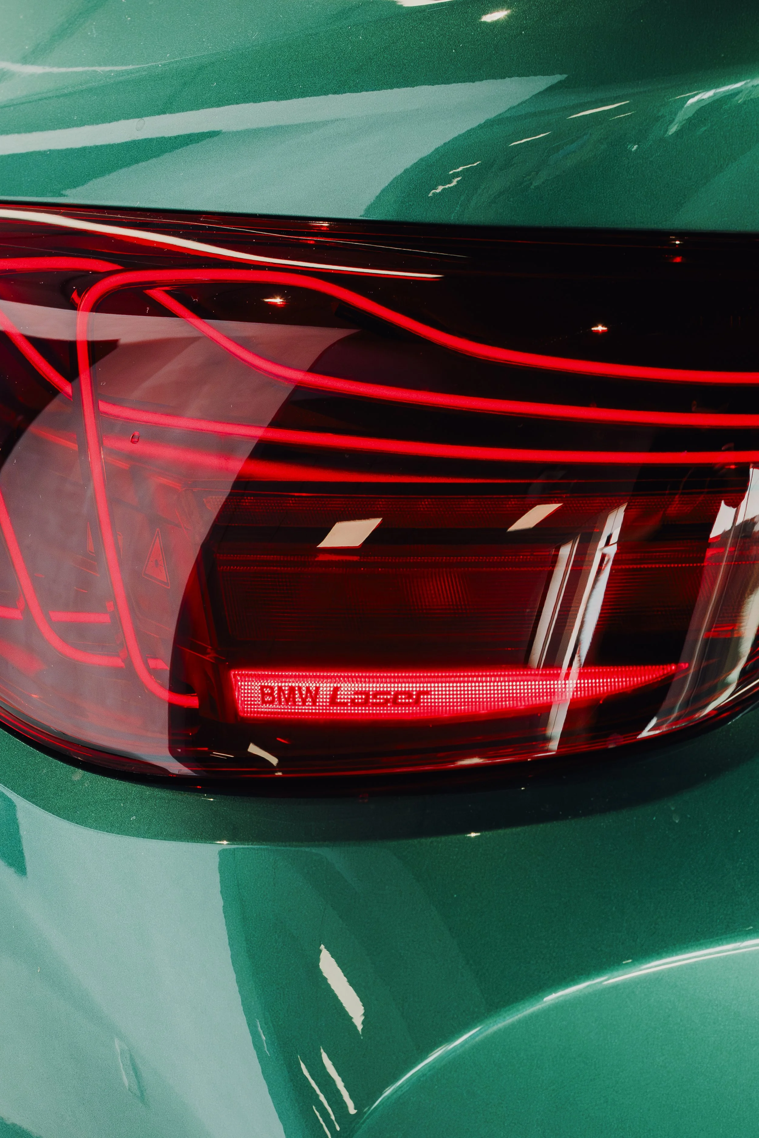 Close-up of the rear tail light of a BMW car with a digital display that reads 'BMW M430'