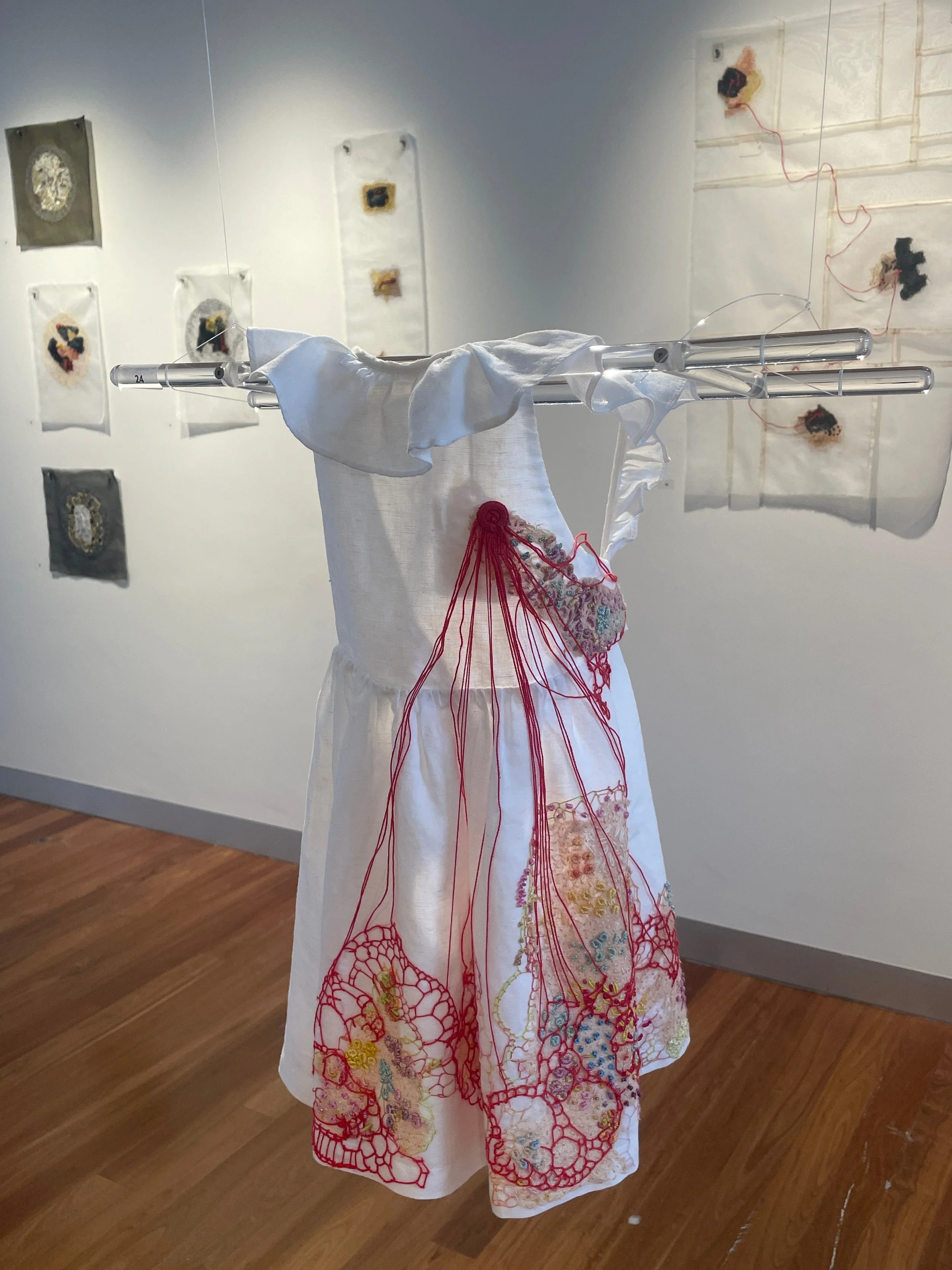 Here begins the cutting board of shape making…, 2026. Improvisational
embroidery on granddaughter’s discarded white frock. Photograph Joy Denise Scott