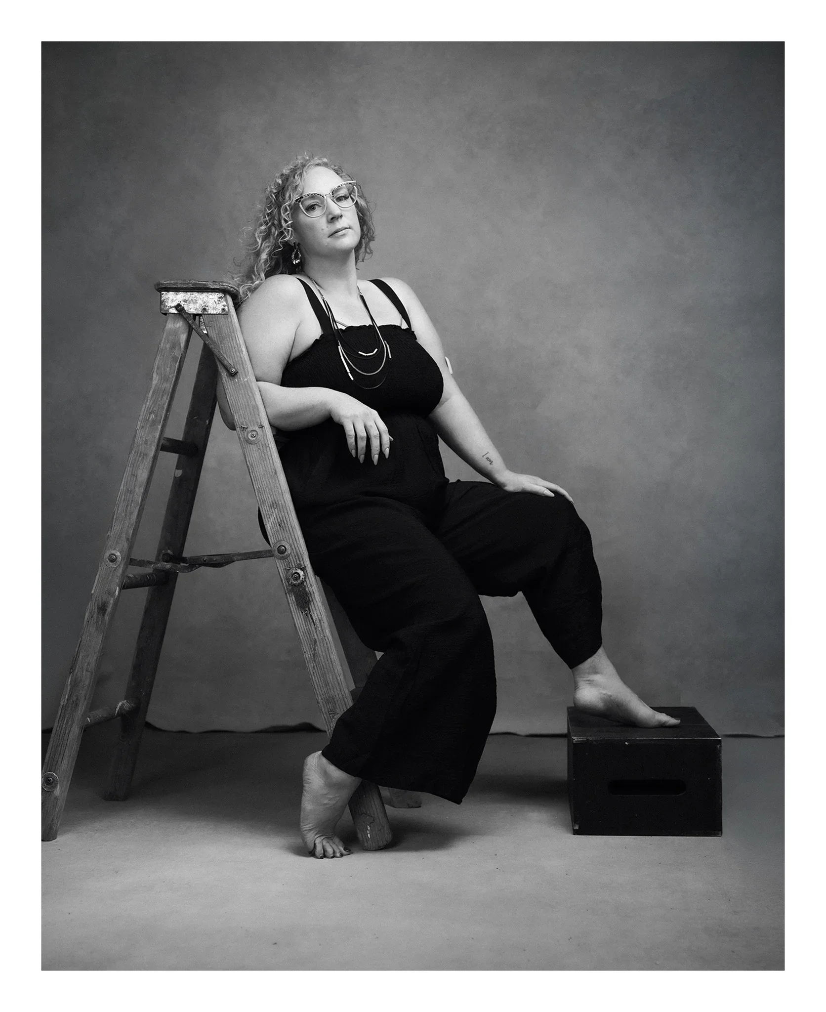 red-deer-portrait-photographer-black-and-white-fashion-leaning-on-ladder.webp