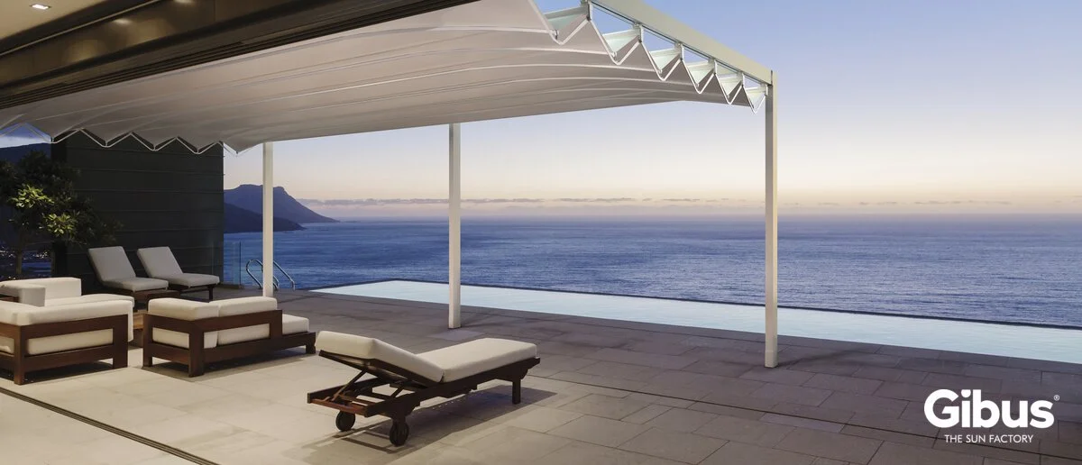 Uima-allasalue terassilla, mattoja ja loungetuoleja, merimaisema ja pyökkipuuta