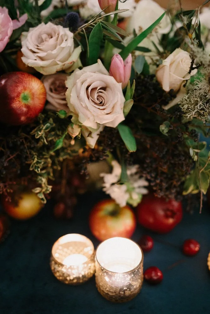 A close up view of the beautiful pale pink roses and red apples floral centerpiece surrounded by tea lights at the Arctic Club Dome Room-Photography by GH KIM-planned and designed by Simply Wed