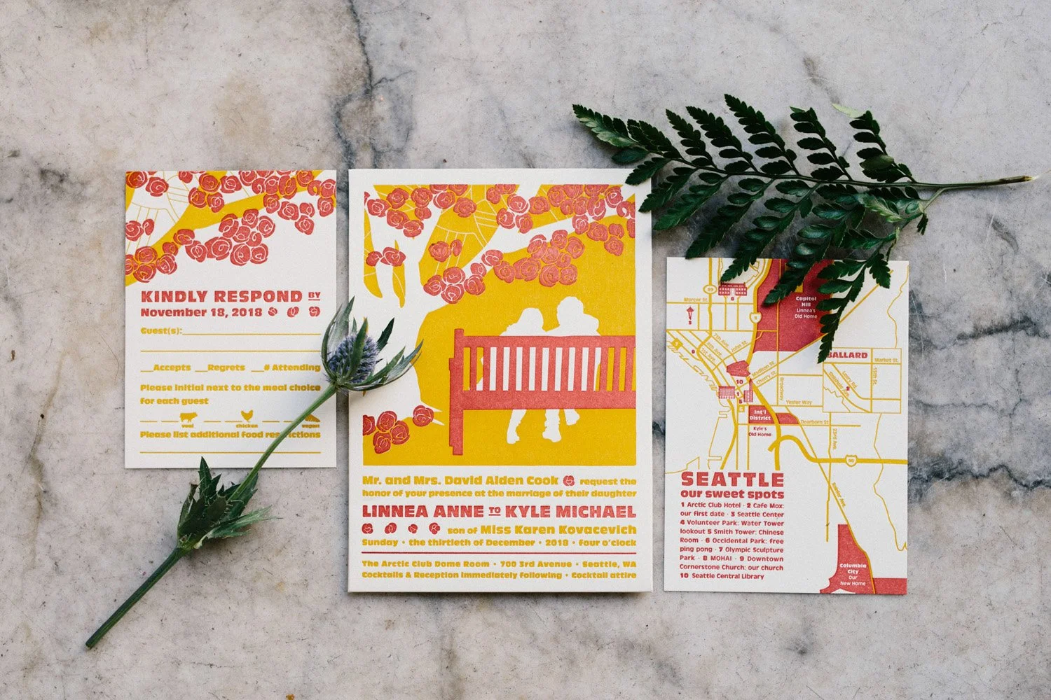 Bride and grooms art nouveau bright yellow and coral pink wedding invitation surrounded by lush greenery at the Arctic Club Dome Room-Photography by GH KIM-planned and designed by Simply Wed