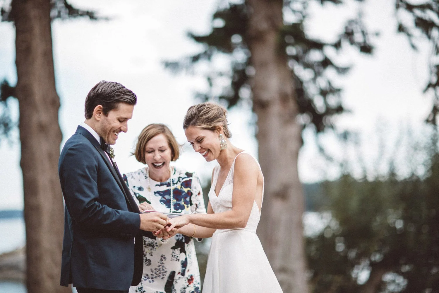 A groom putting a ring on his bride's finger at their Pebble Cove Farm wedding on Orcas Island, planned and designed by Simply Wed.