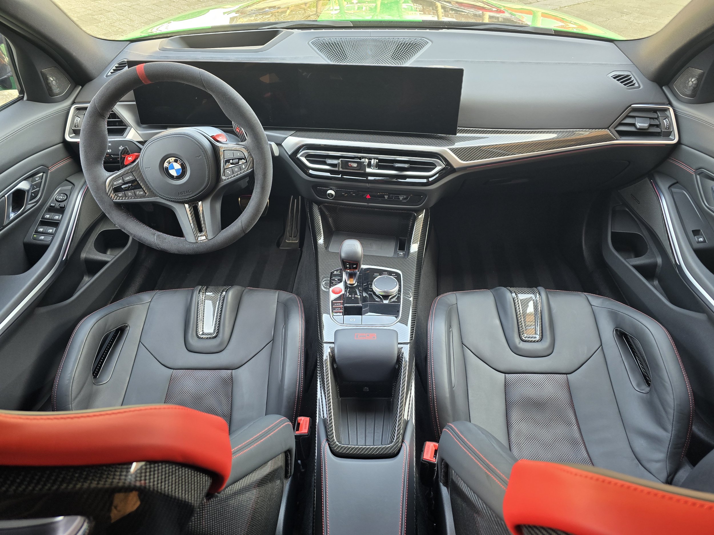 Interieur van BMW sportauto met stuur en dashboard.