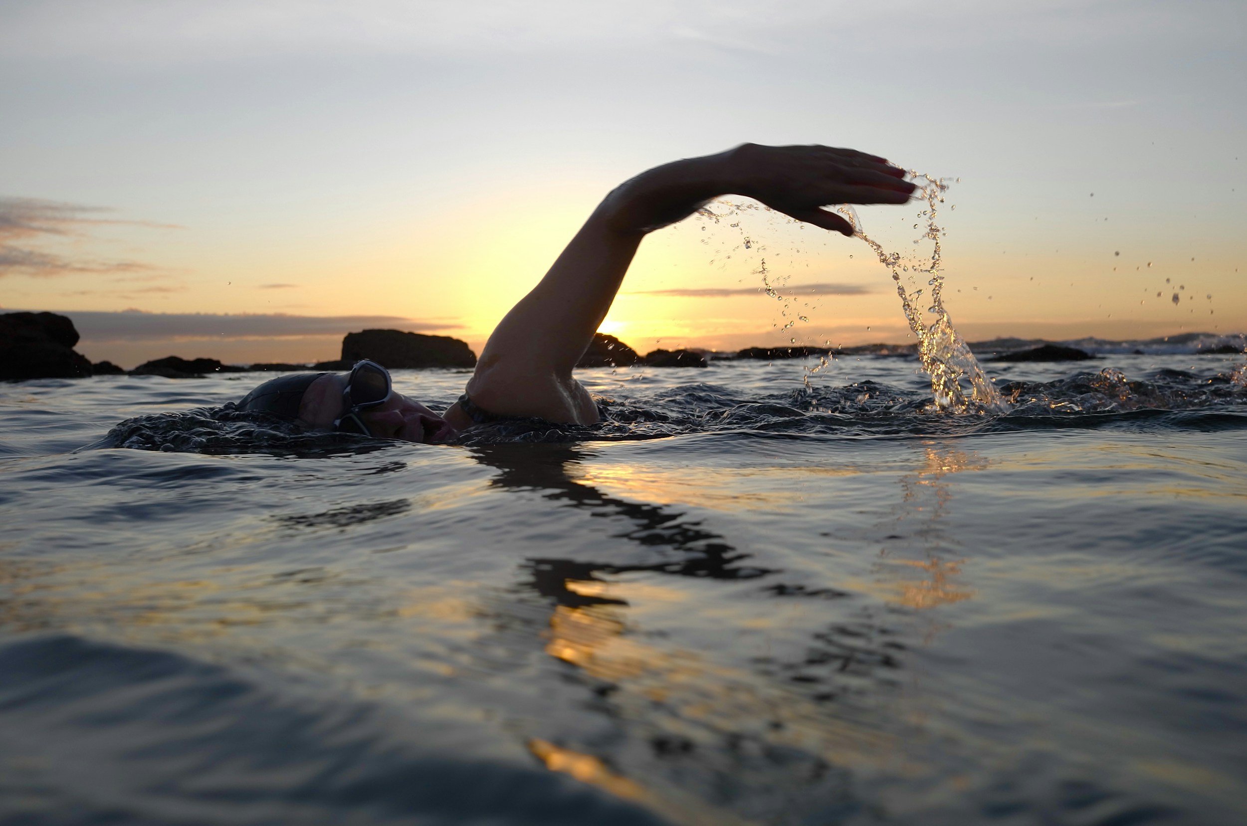 Natation en crawl au coucher du soleil, une activité recommandée après une prothèse de genou