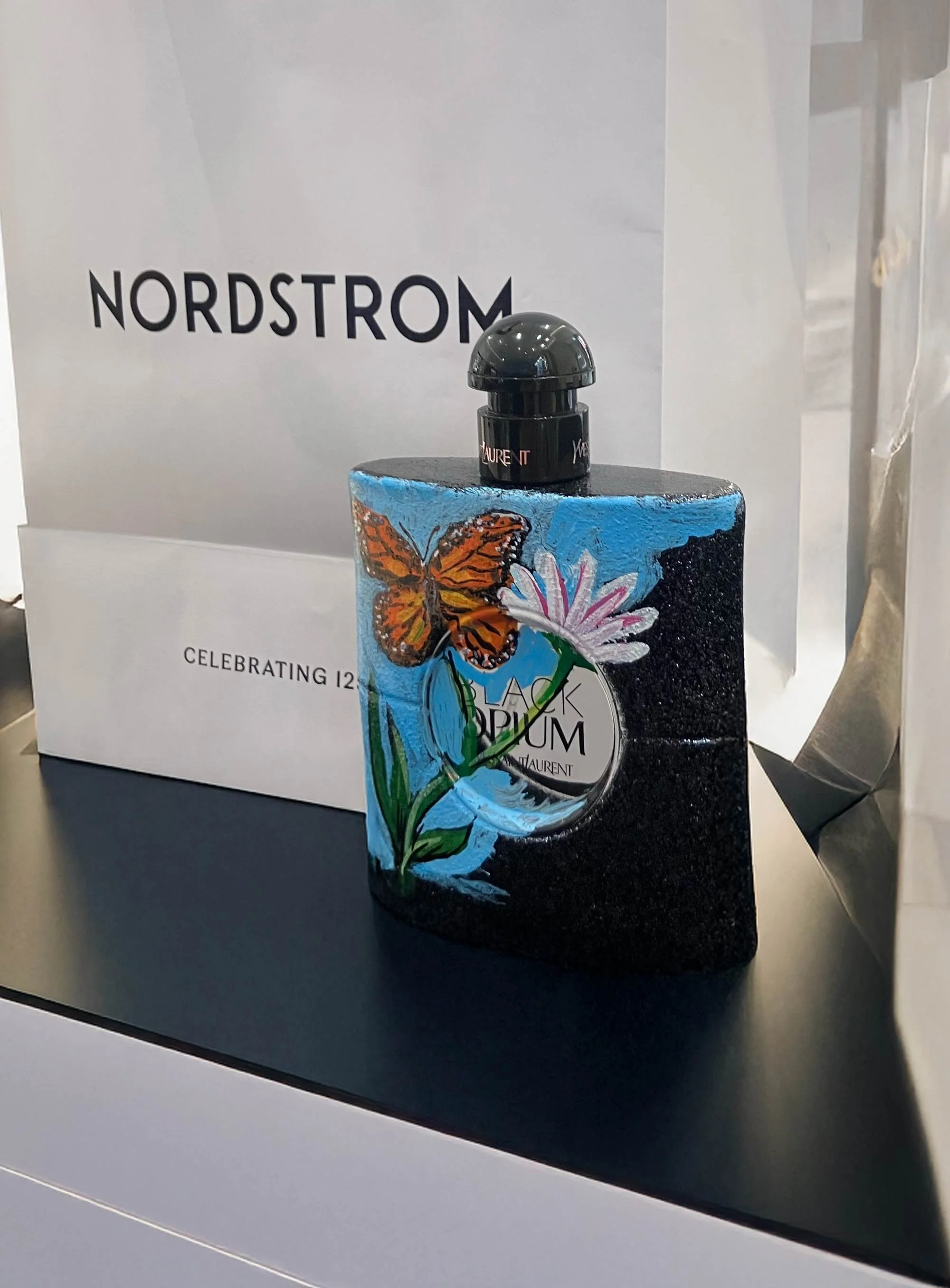 In store brand activation fragrance bottle painting for Nordstrom with butterfly design