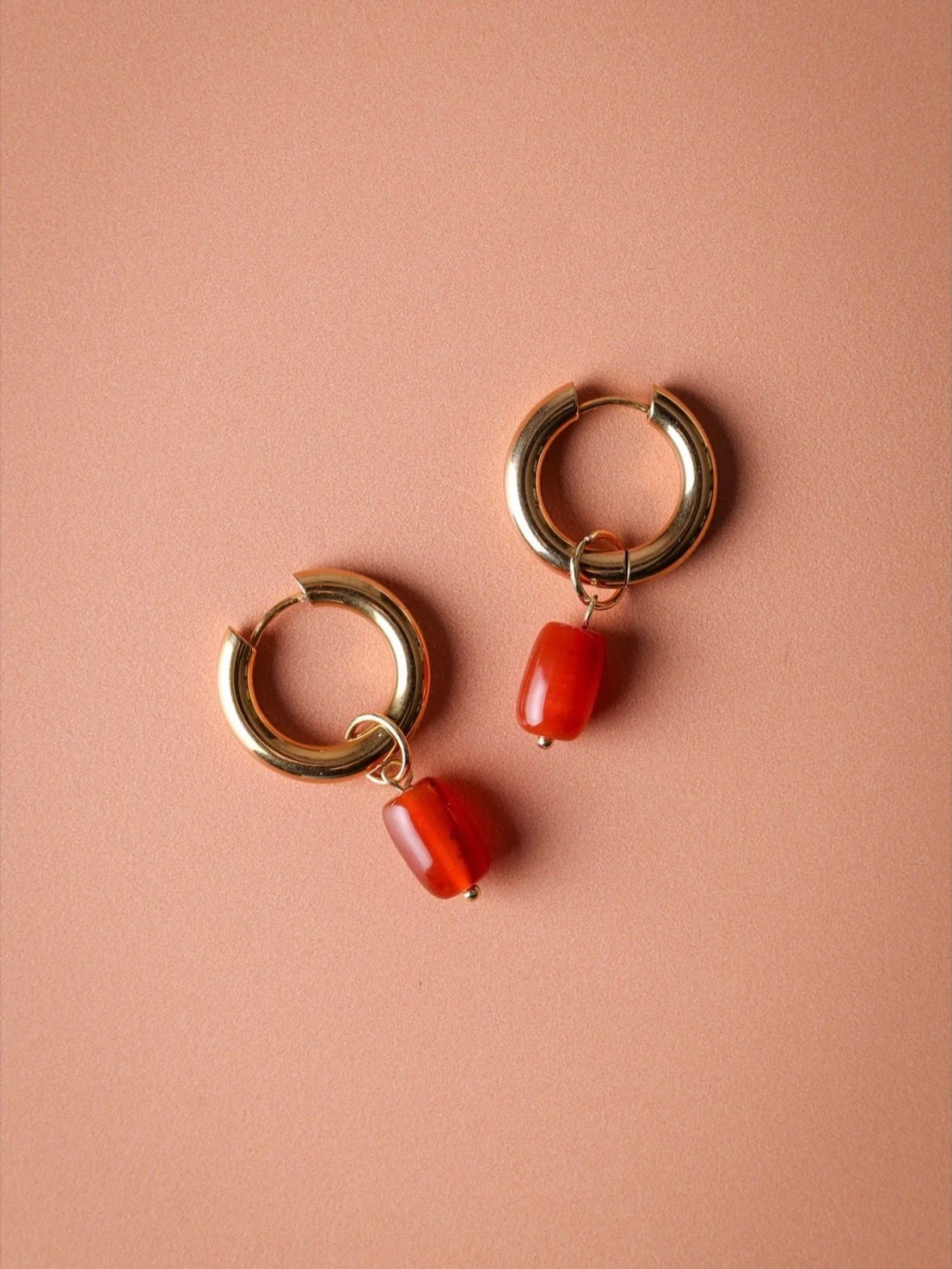 Turn up the energy with a vibrant pop of colour. These elegant hoop earrings finished with a glowing carnelian drop bring warmth, confidence, and effortless style to any look.