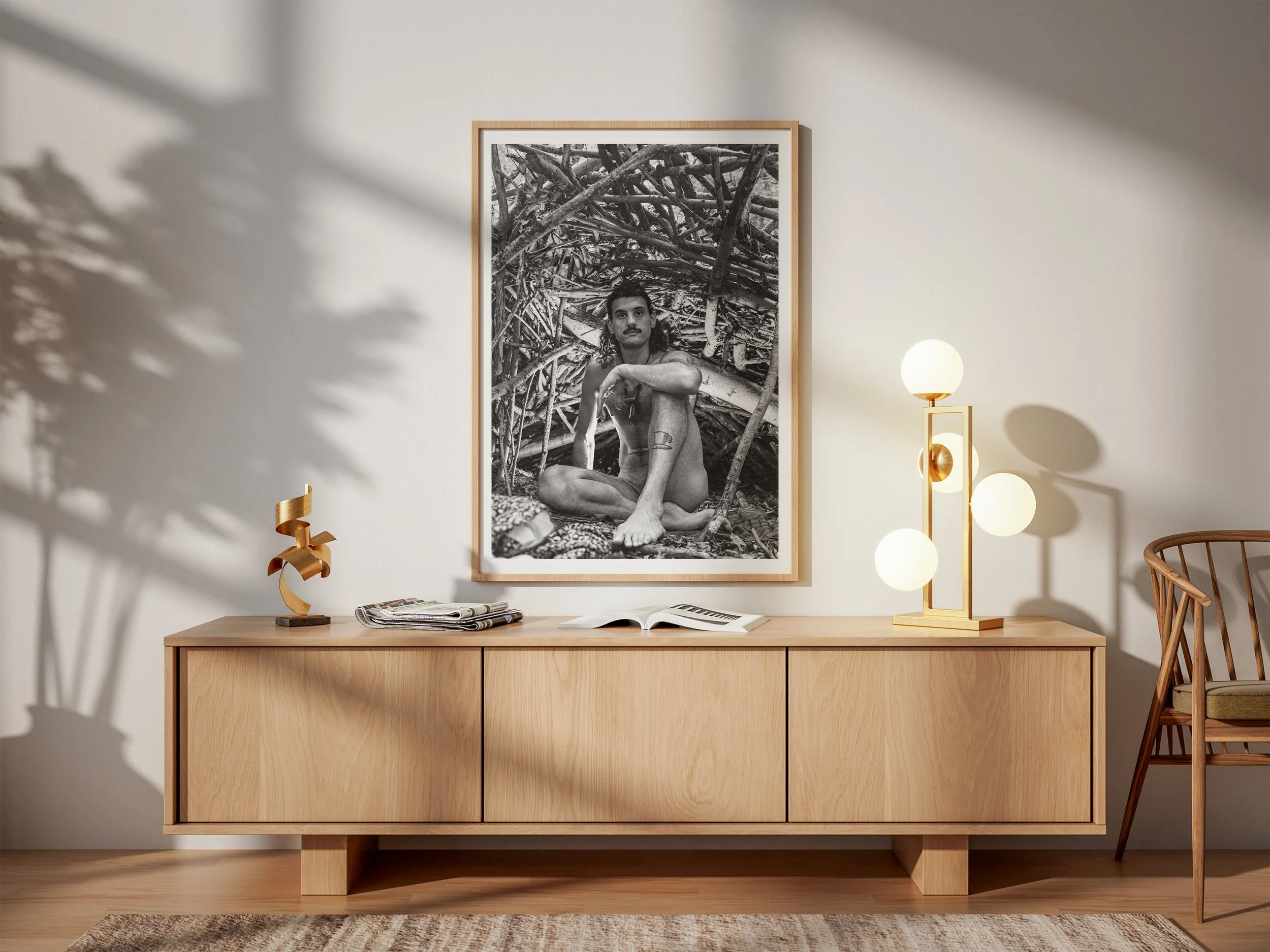 Minimalist design of a lounge room with wood and metal furniture, showing a fine art photography in black and white, framed with natural wood.