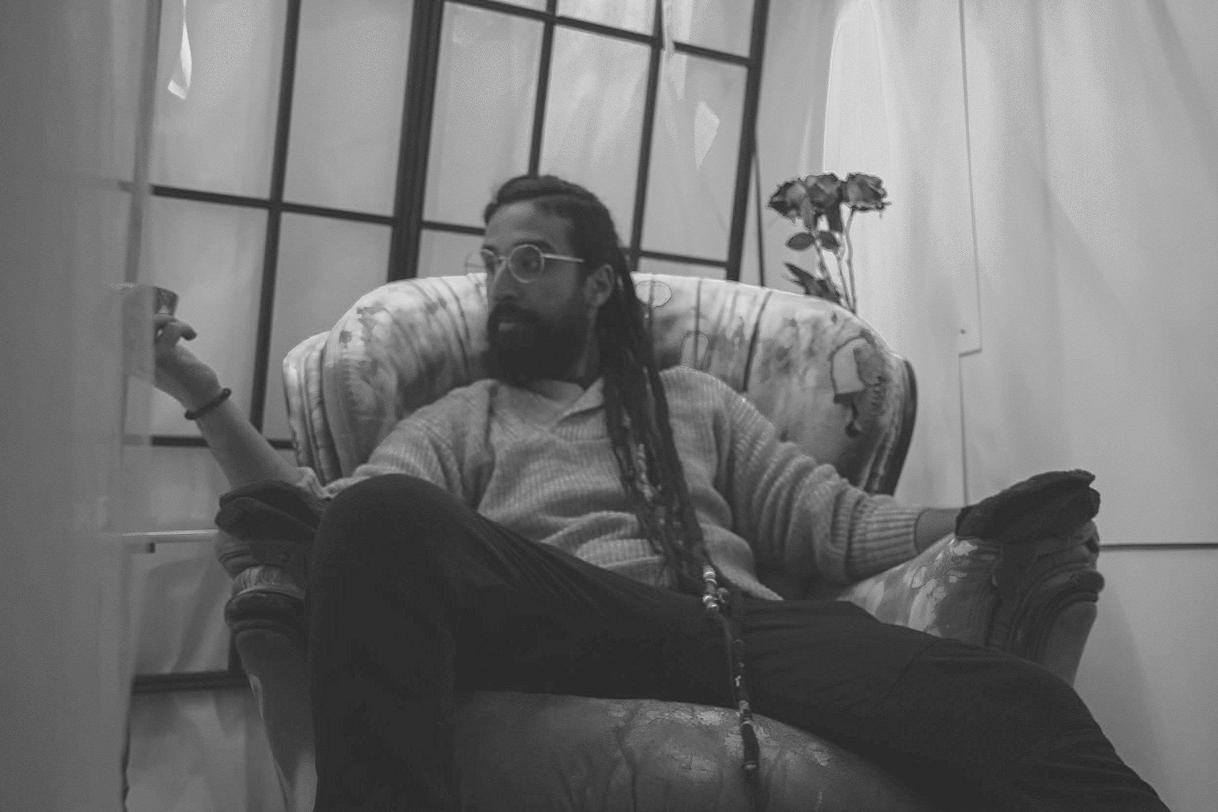 Fine art photographer Frankie Breakfast in a reflective studio setting. He is an Italian artist based in Turin specializing in conceptual and emotive photography