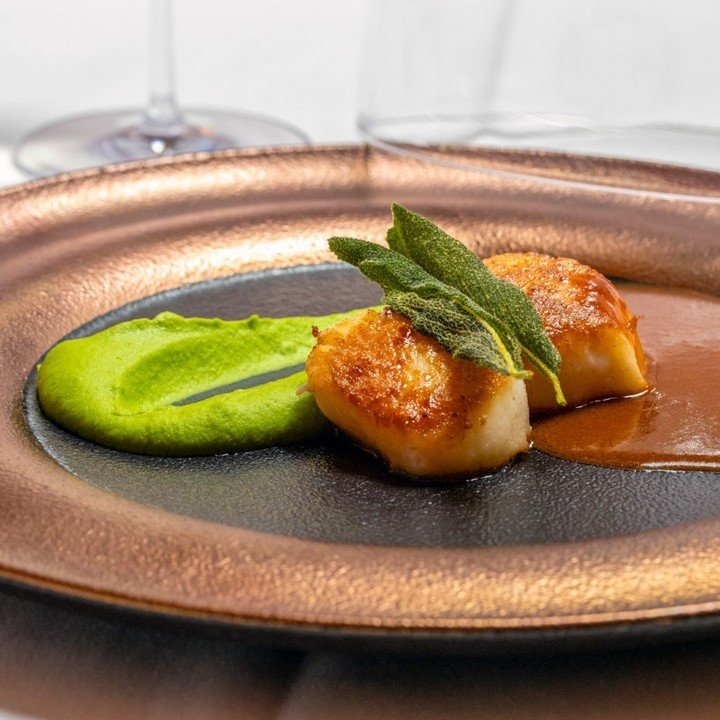 Another one of our guests' favorites: Cocody's Seared Scallops! Elegantly embraced by English pea pur&eacute;e and a lively Spanish Fermin chorizo broth, each scallop is a burst of sea-kissed flavors, crowned with tableside smokiness. A culinary mast