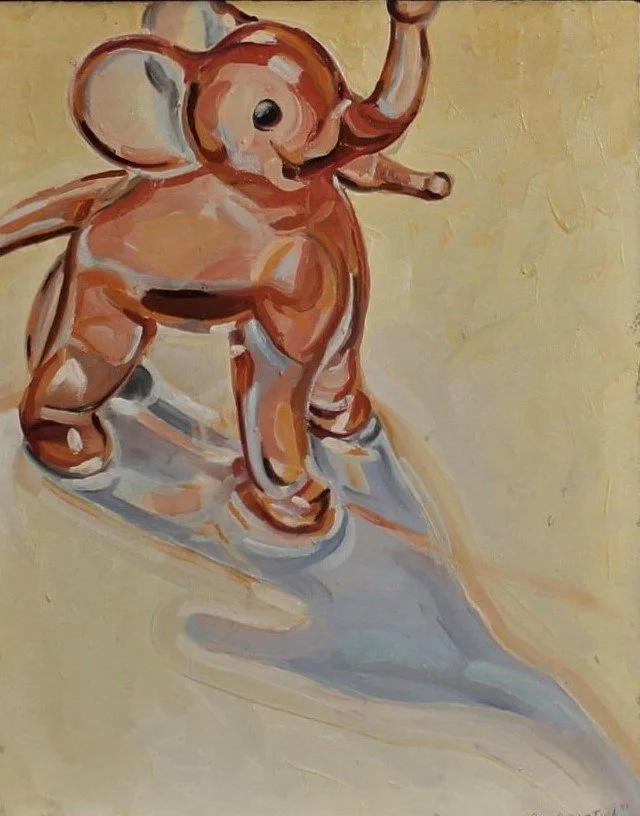 A pink glass elephant figurine under a spotlight, casting a long shadow across the surface.