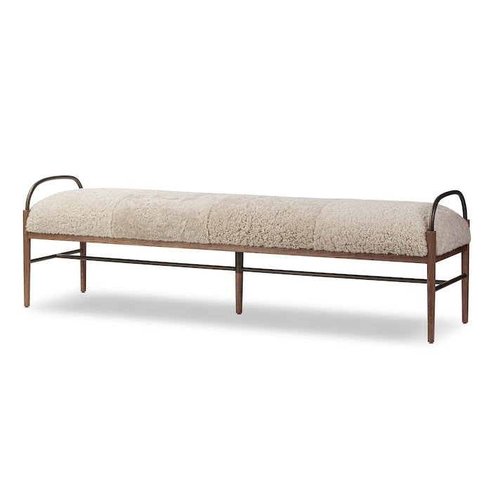 A modern bench with a wooden frame, metal legs, and a cushioned, textured beige fabric seat.