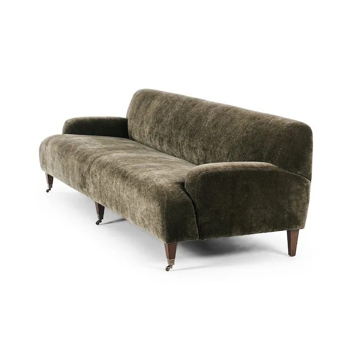 A vintage-style olive green velvet sofa with wooden legs and casters on the front legs, set against a plain white background.