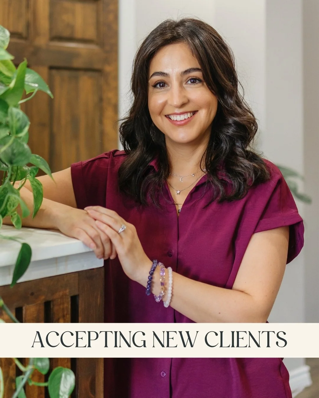 Lucia Romero, RP (Qualifying) - A smiling woman with long dark hair, wearing a purple blouse, and leaning on a wooden counter with a green leafy plant nearby and a caption that reads "Accepting New Clients."