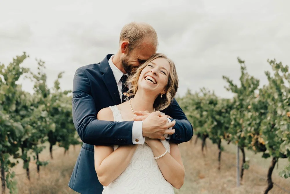 A couple cuddling in the vines a murrumbateman winery on their wedding dayNSW