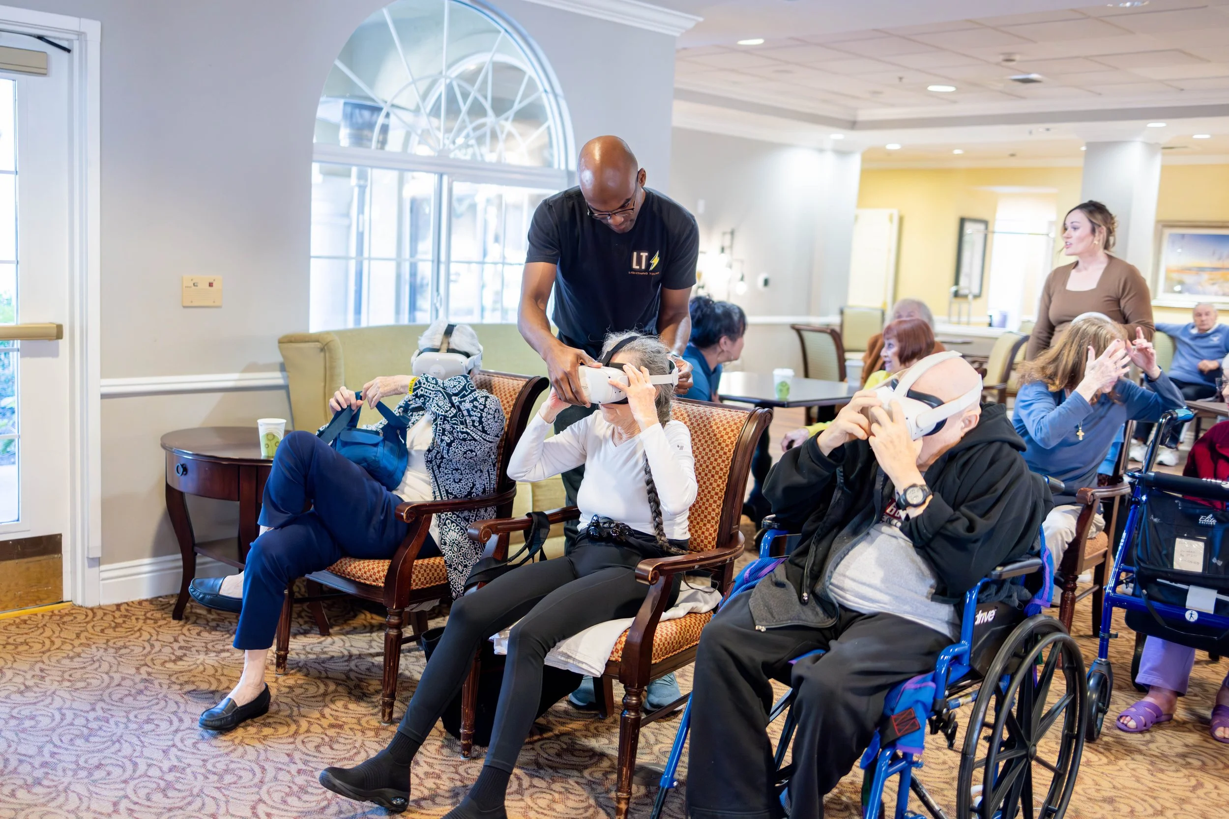Lightning Tours guide helping a senior resident use a VR headset