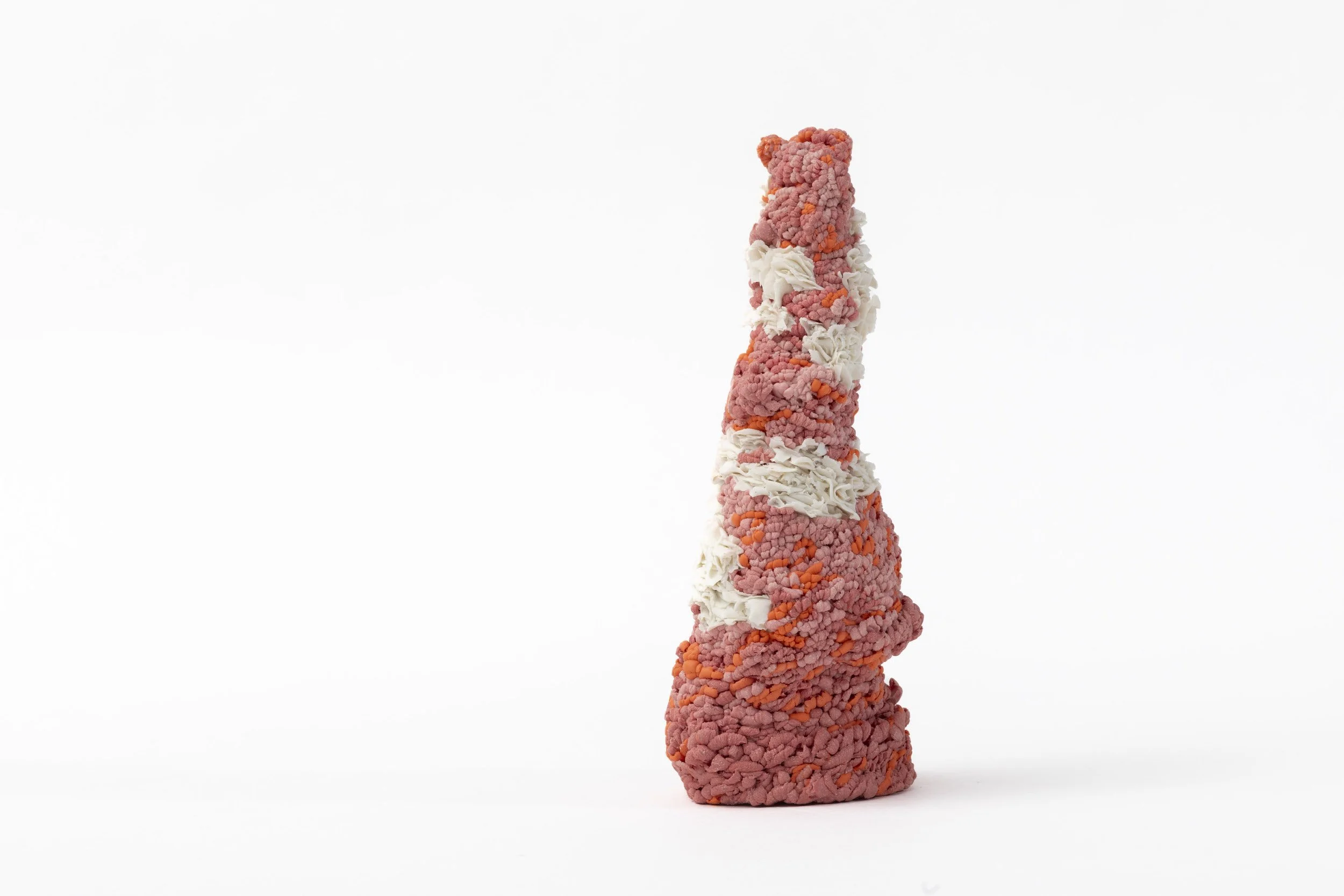 Hand-built porcelain sculpture with a vertical form and layered pink textured surface on a white background.