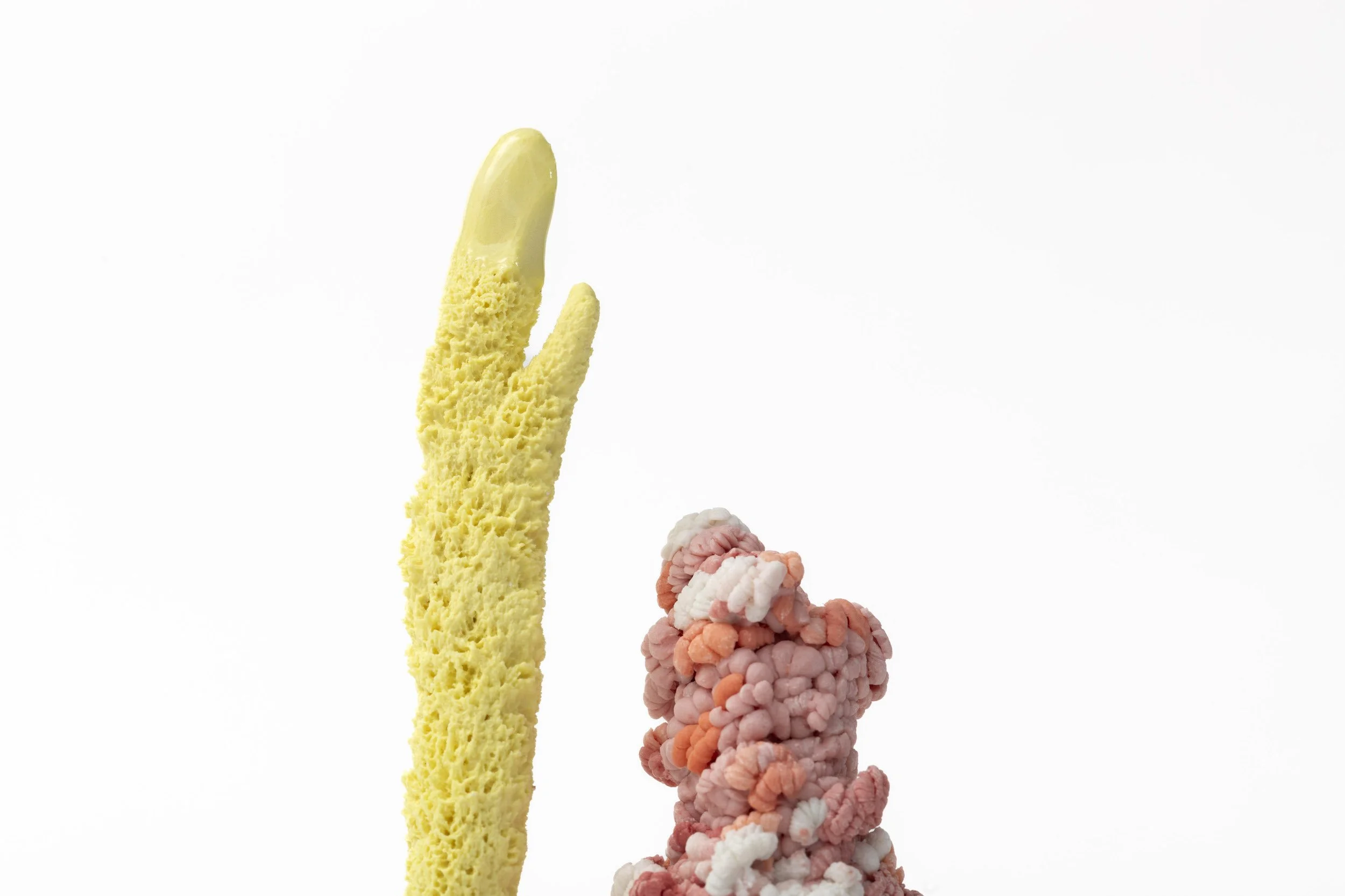 Detail of hand-built porcelain textured sculpture with a yellow stem.