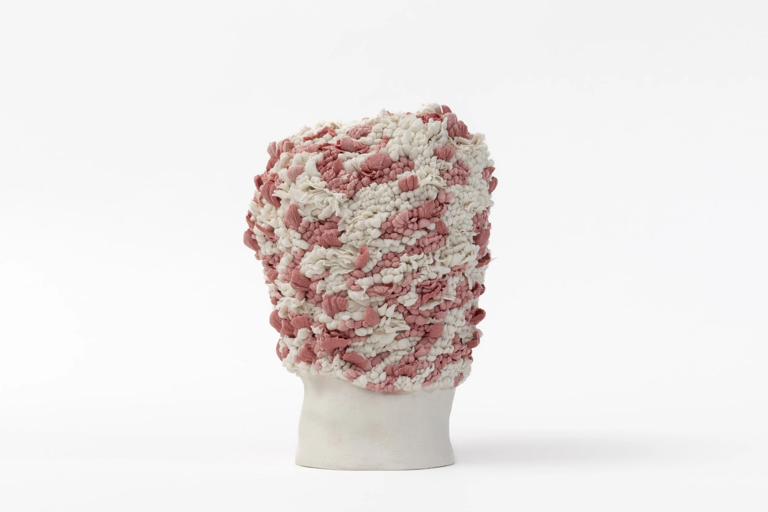 Hand-built porcelain sculpture with a rounded abstract form, textured pink and white clustered surface. 