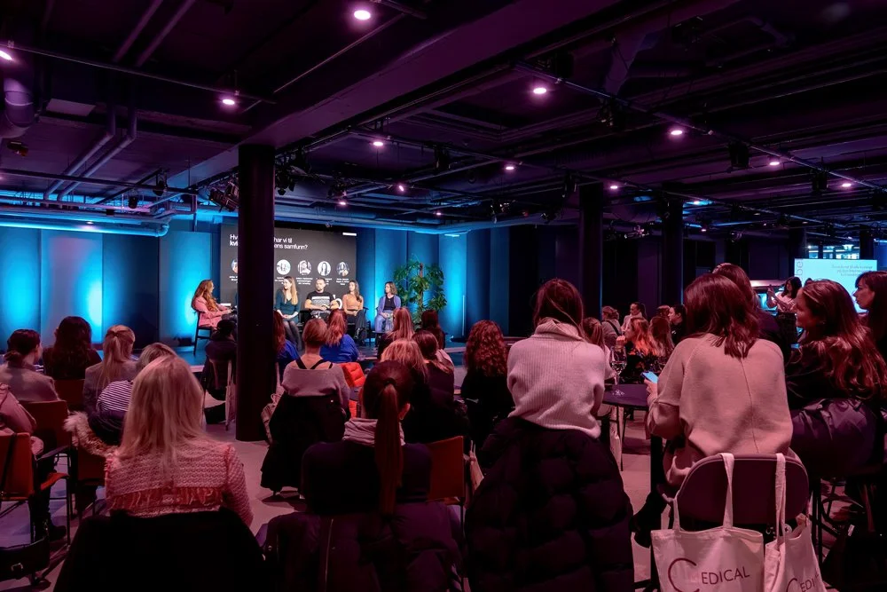 Panel discussion event with audience in a dimly lit room