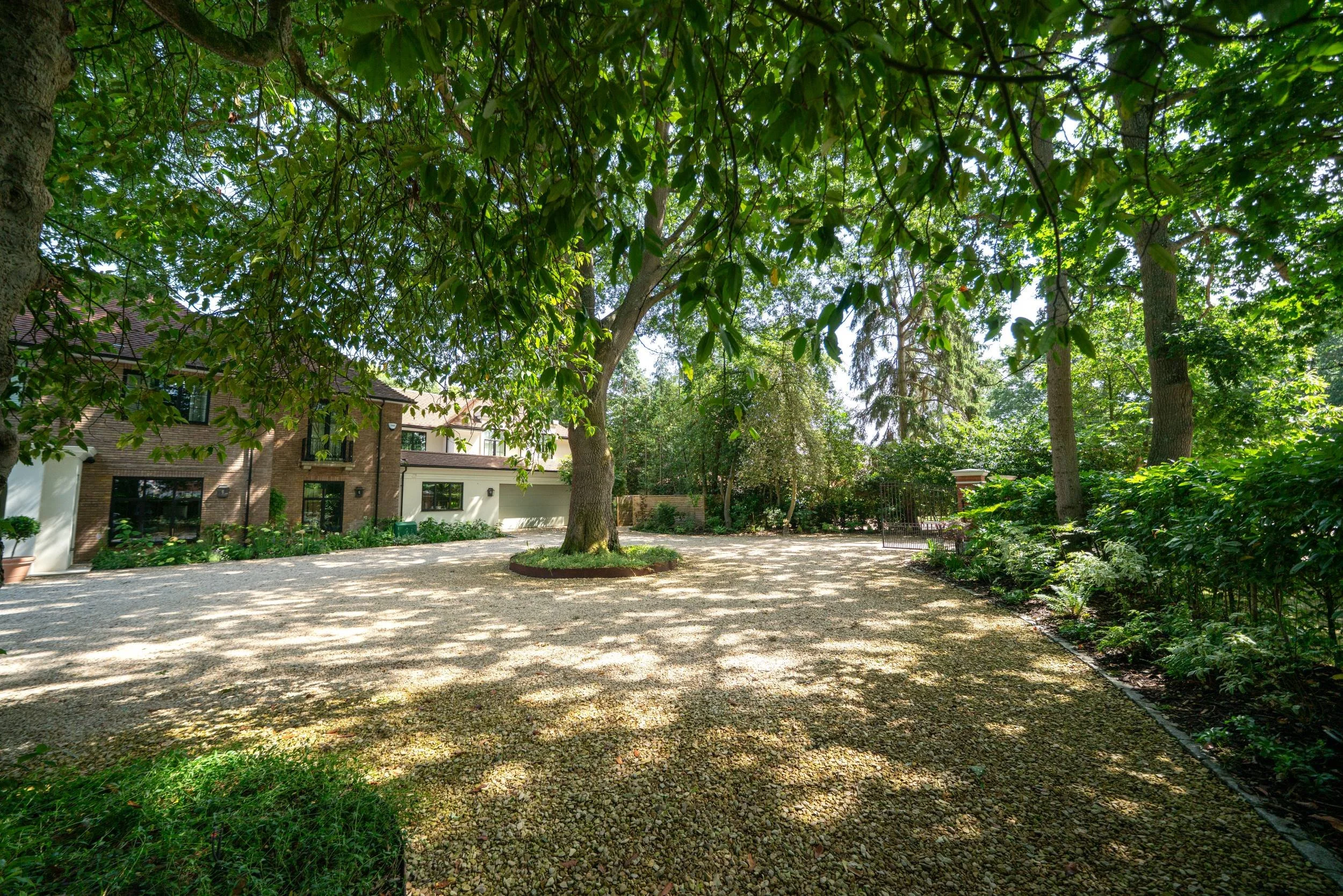 Drive under mature trees with the house behind, Weybridge
