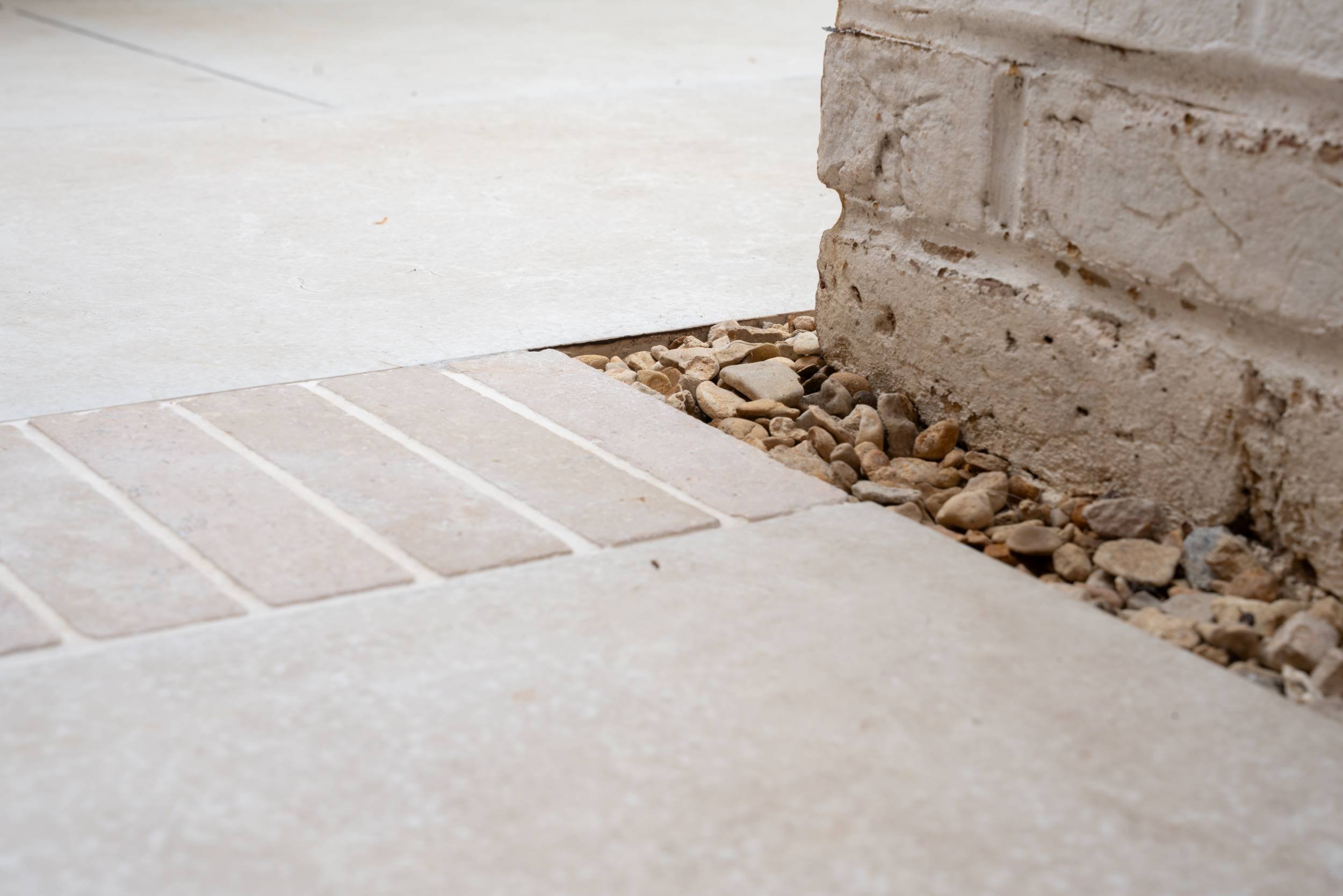 Paving meeting a gravel margin in a small town garden in Cobham