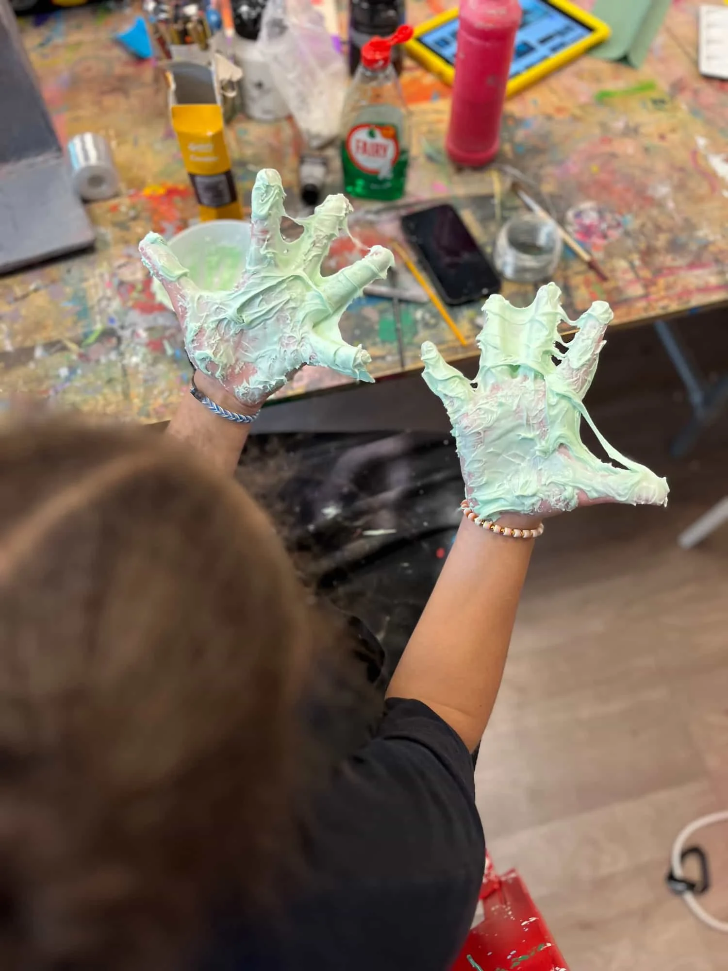 Open palms covered in homemade slime