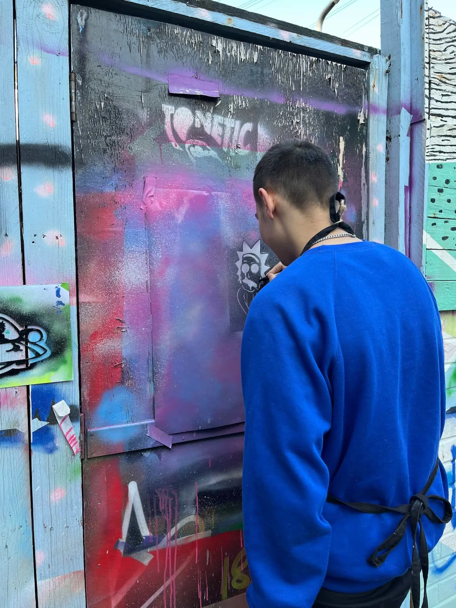 Young person drawing around their stencil in our courtyard