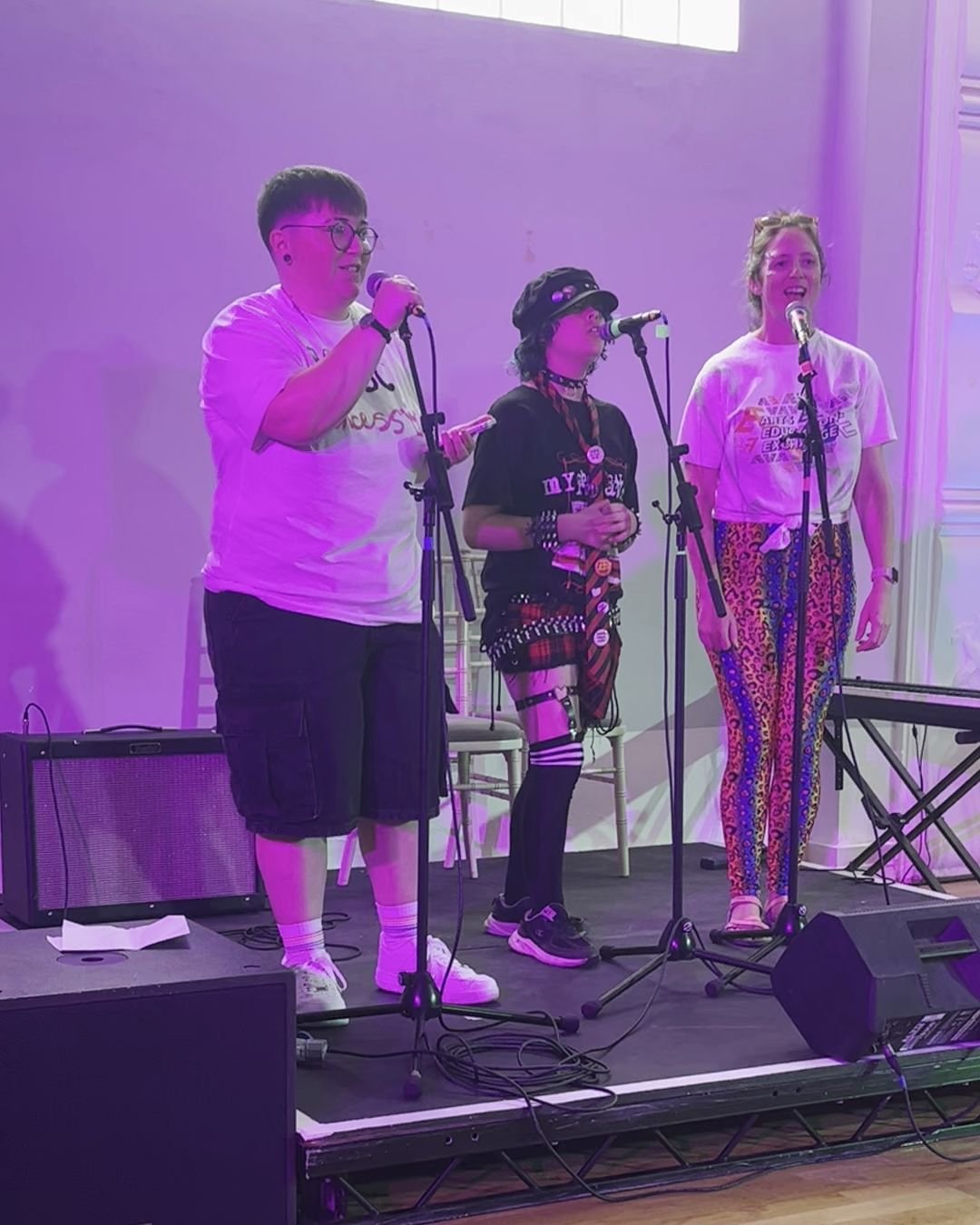 Two young people and a staff member performing together at youth pride.