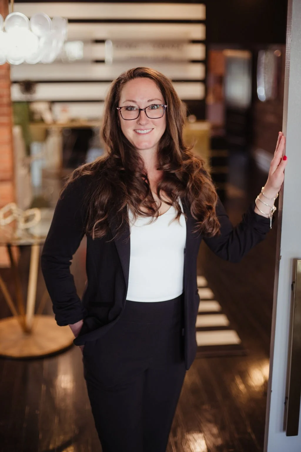 a woman in a black jacket, white shirt, smiling