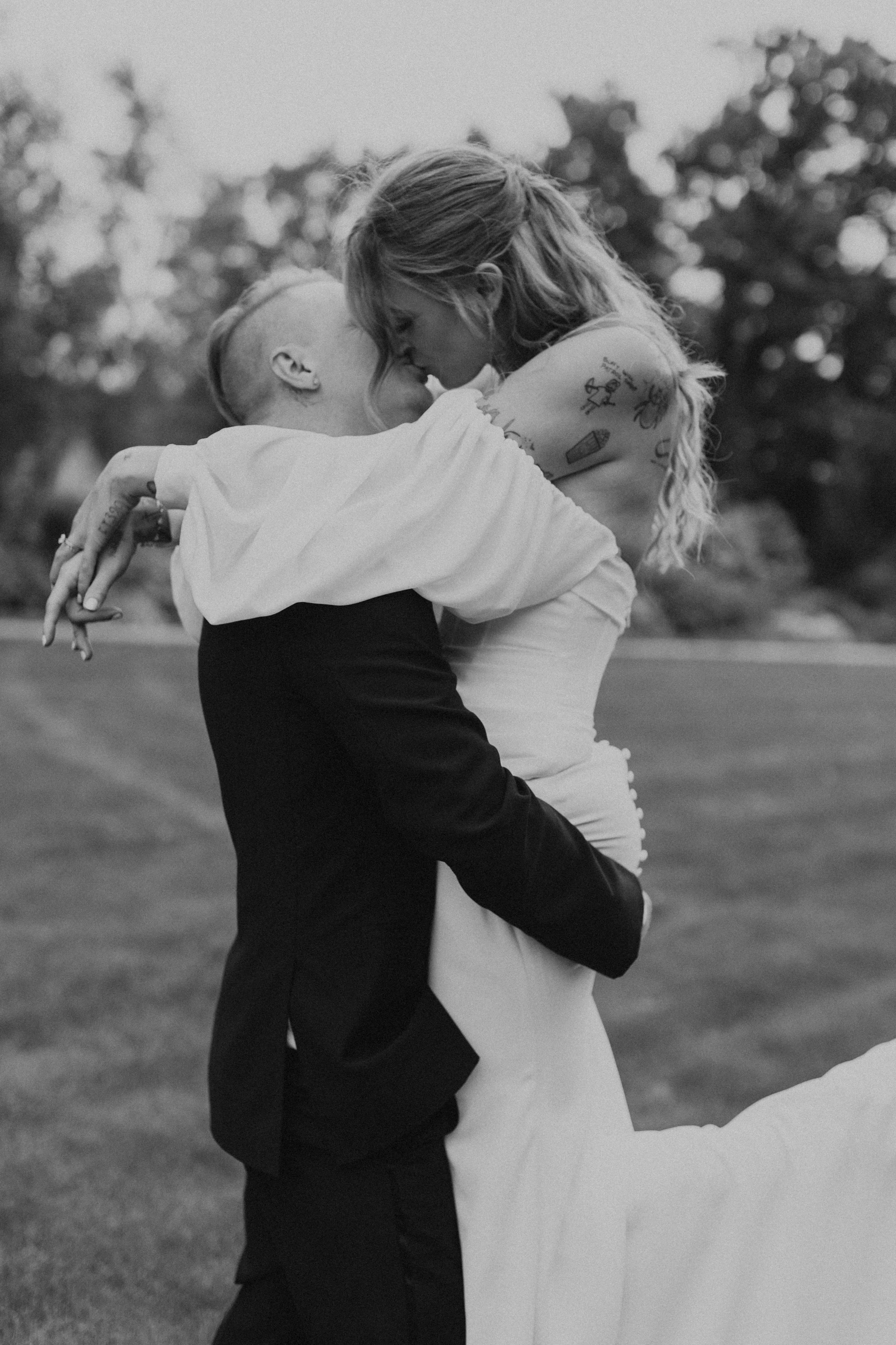 close up of groom picking up bride and kissing her