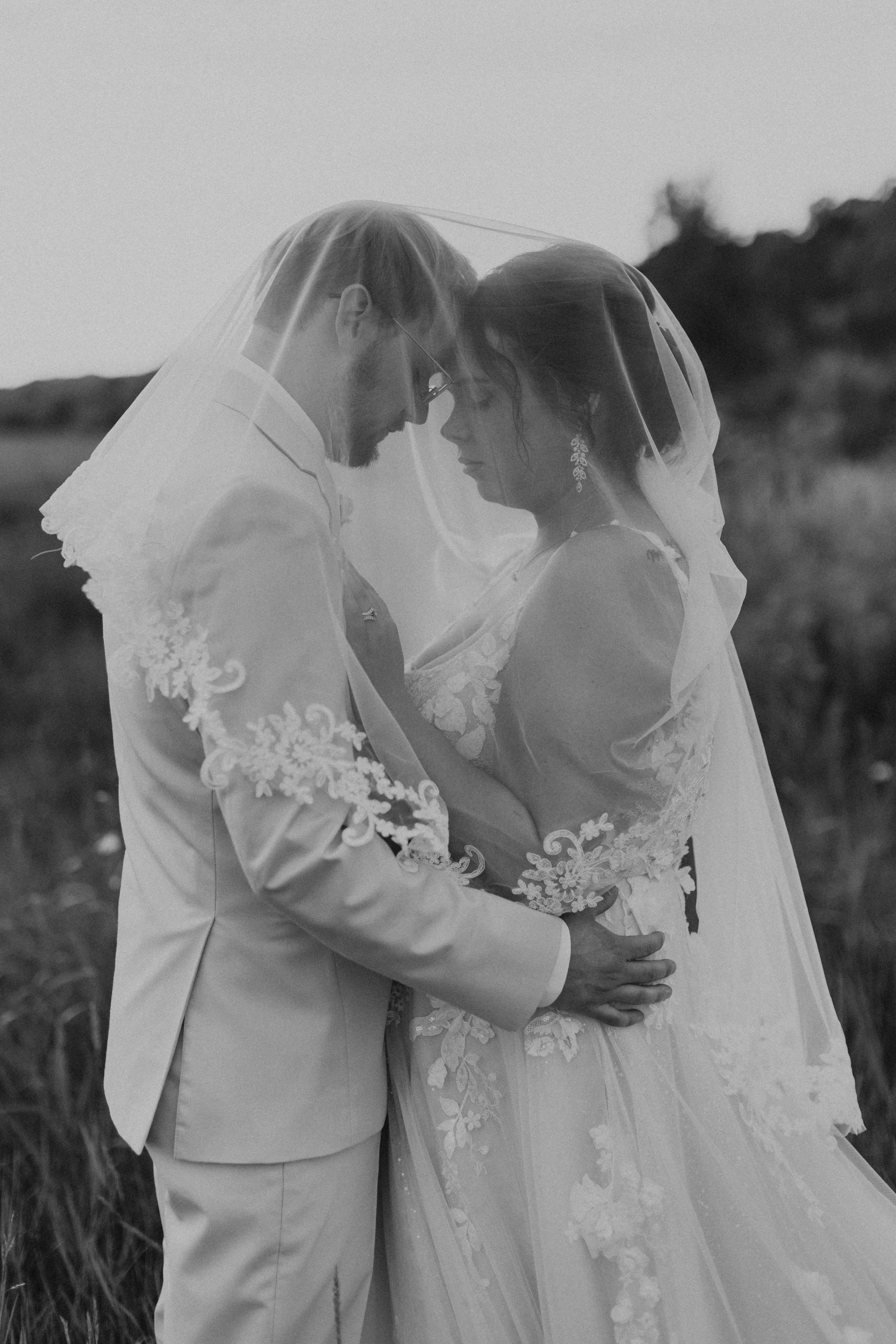 couple embracing closely in grassy field